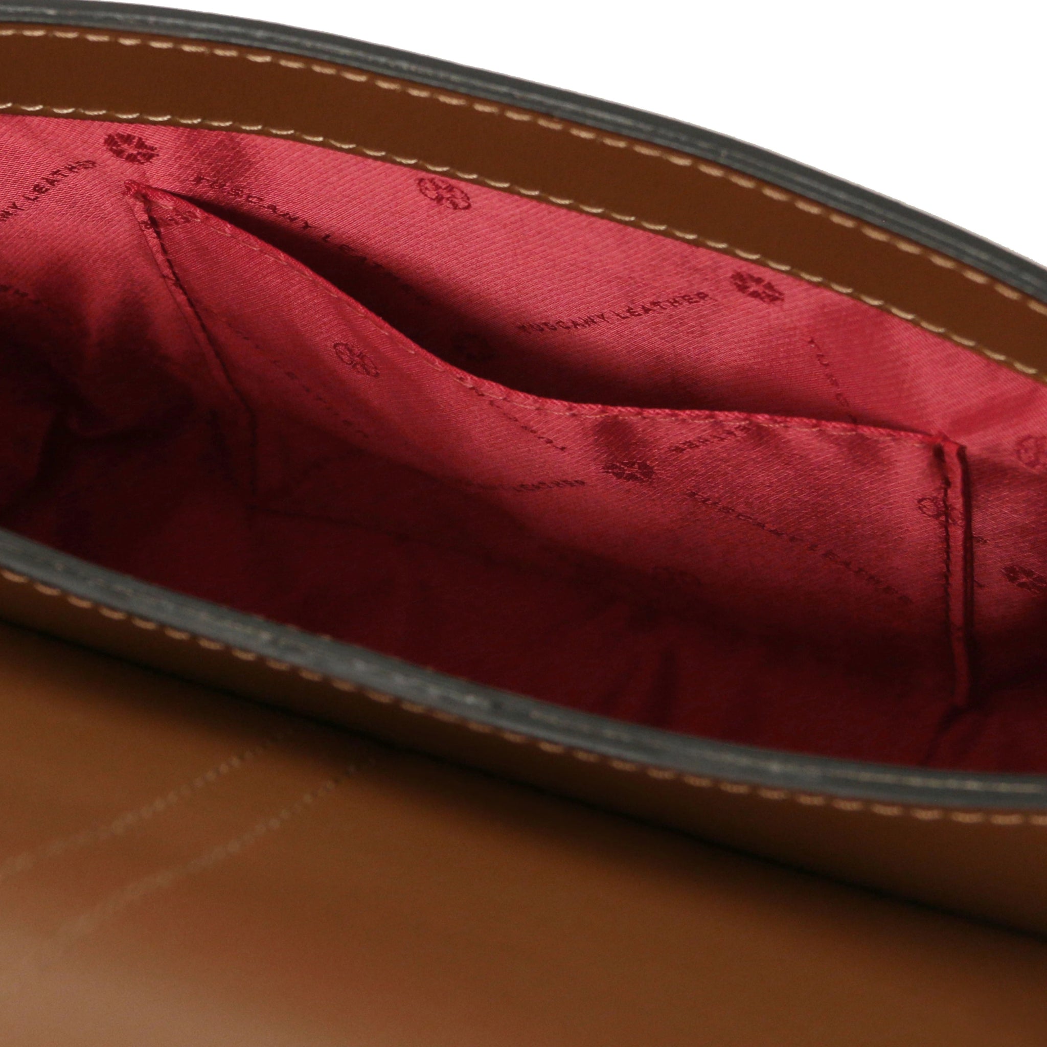 Interior zip pocket view Nausica Italian Leather Shoulder Bag in cognac showing red bag lining