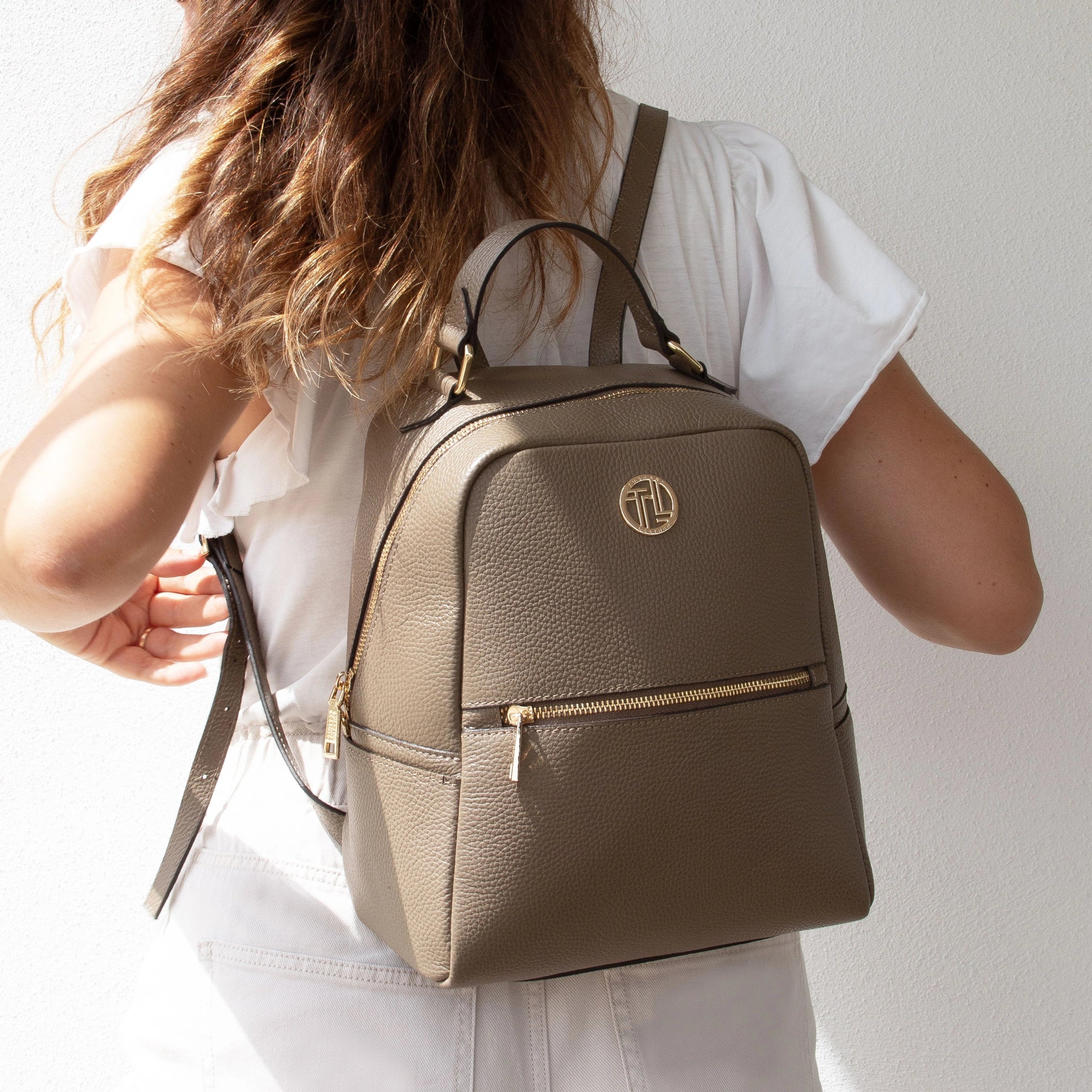 A woman wearing the Prisma Italian Soft Leather Backpack in dark taupe