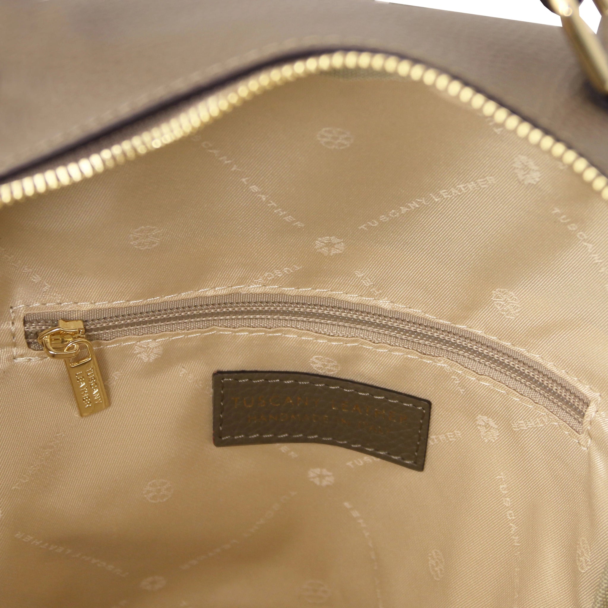 Interior zip pocket view Prisma Leather Backpack in dark taupe with beige lining