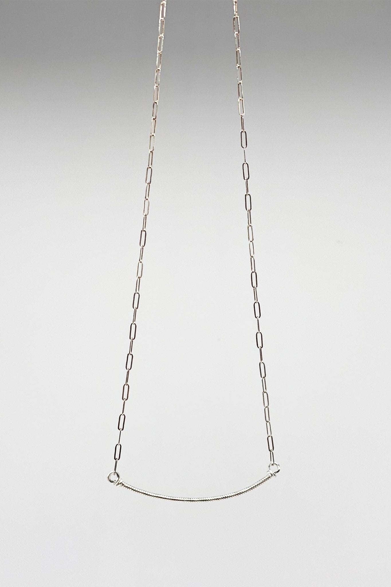 Signature Wrap U Necklace in Silver on a light gray background