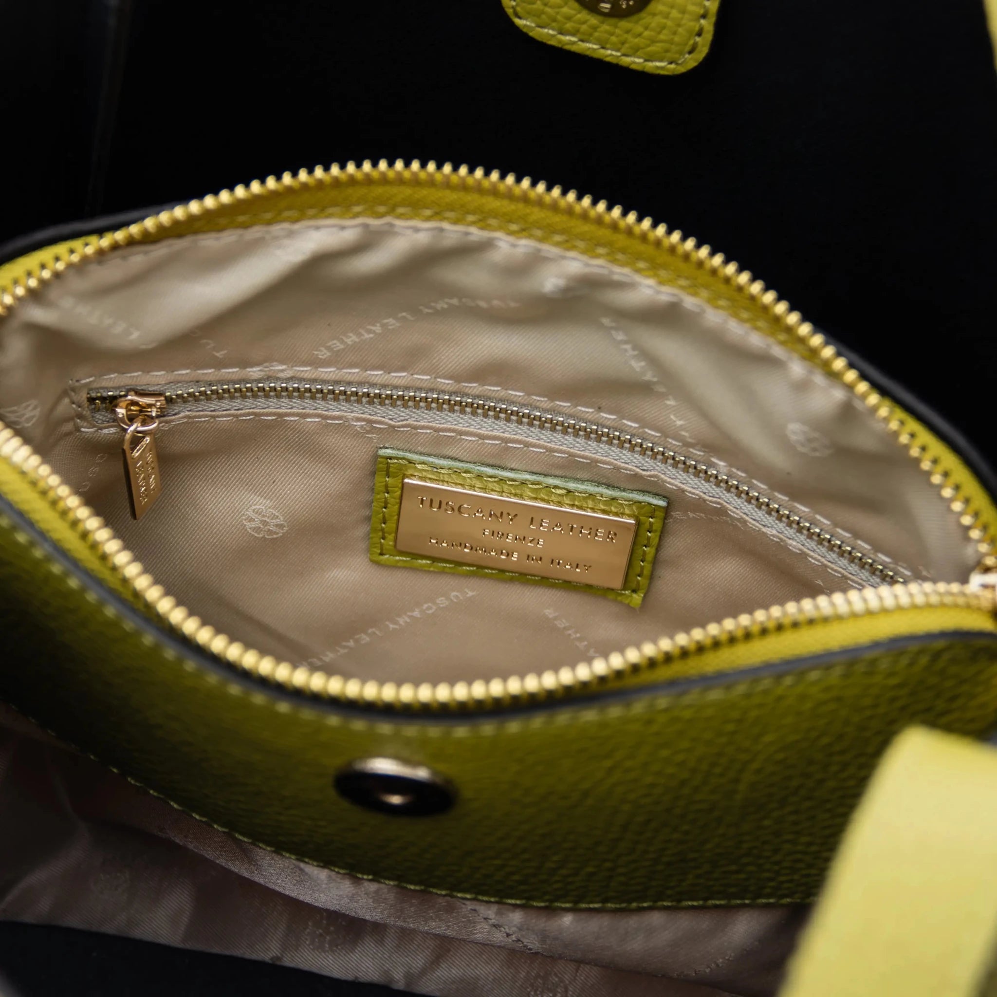 Interior zip pocket tan lining view Soave Soft Leather Handbag in green on white background