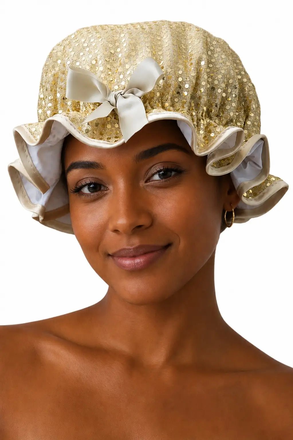 Woman wearing a gold sequin bonnet with ruffles and a white bow on a white background