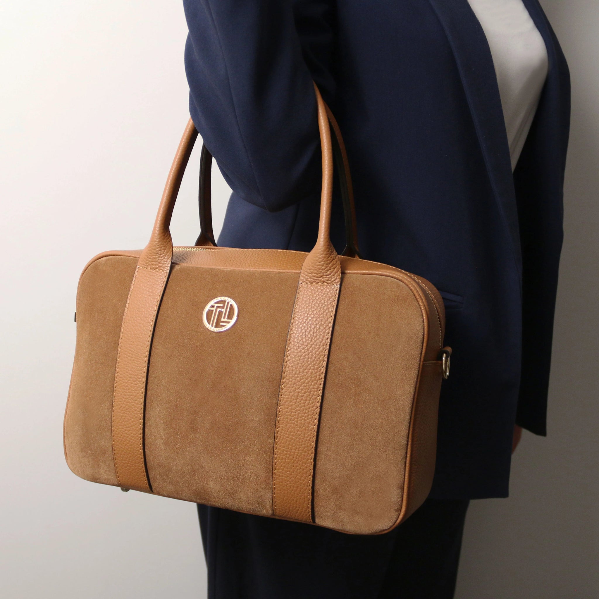A woman is carrying the Stephany Italian Suede Leather Handbag in Cognac