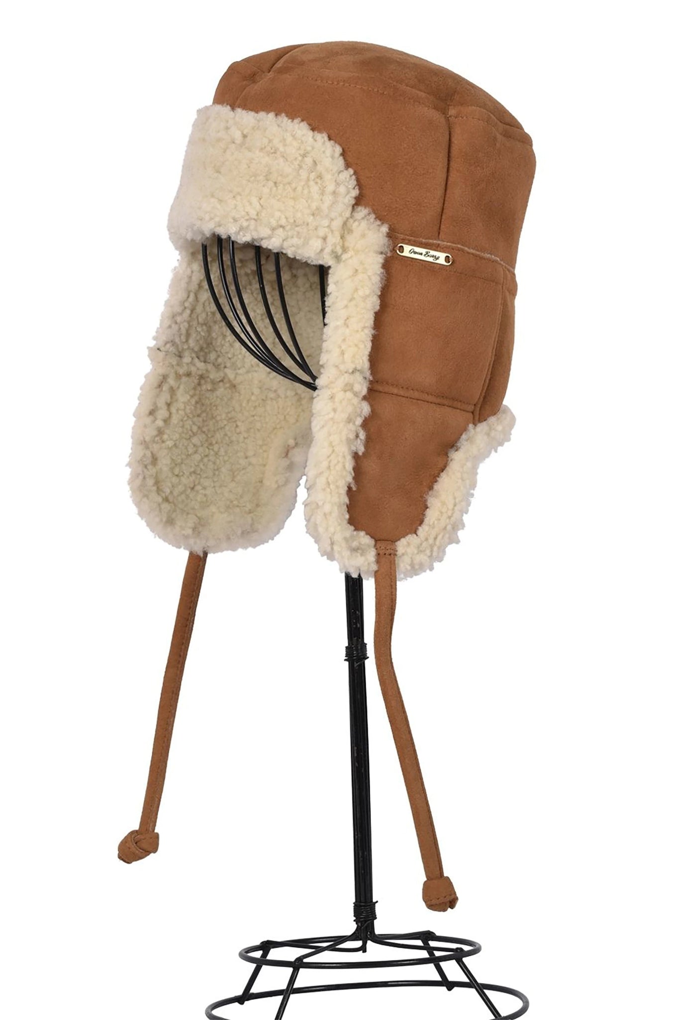 Side view Tie Trapper Sheepskin Ear Flap Hat in Brand Cream on a black hat stand, ear flaps down