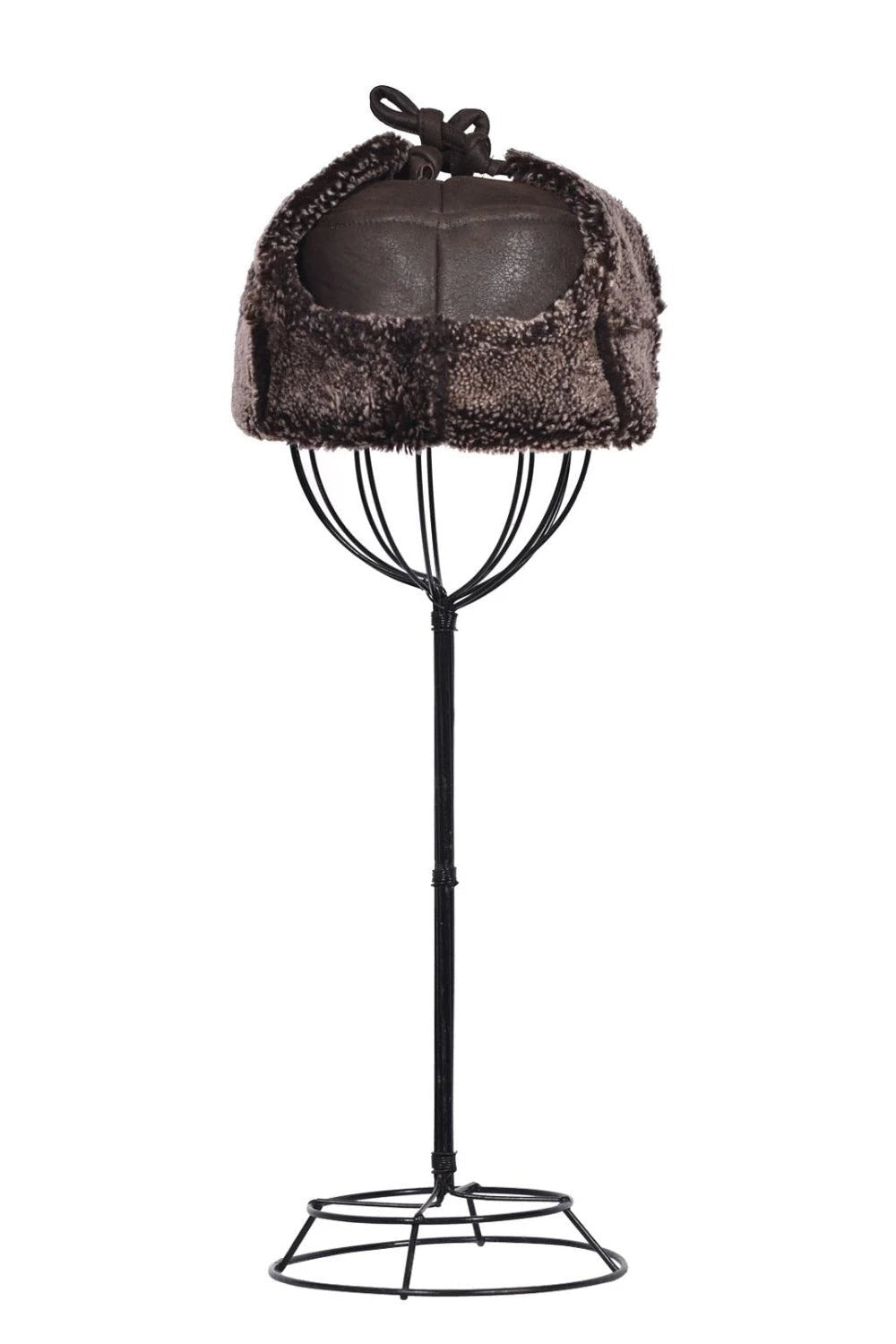 Tie Trapper Sheepskin Ear Flap Hat in Dark Brown on ear flaps tied up on a black hat stand, front view