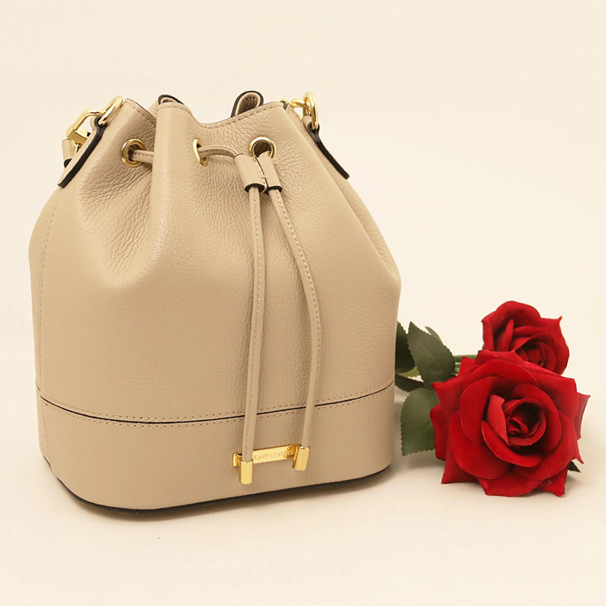 TL Italian Leather Bucket Bag in beige next to two red roses