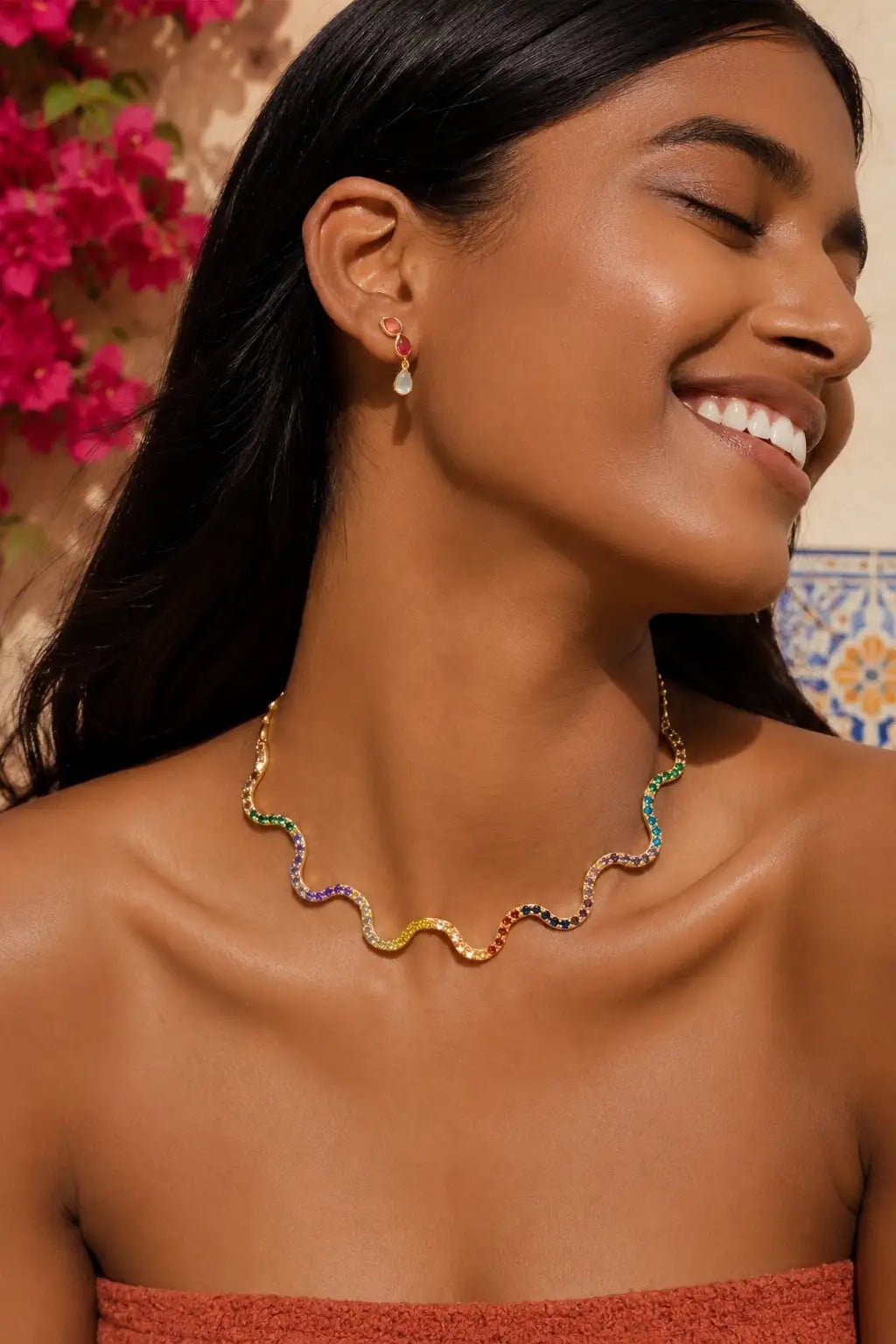 Woman wearing the Villajoyosa Scalloped Spanish Gold Choker with a blurred floral background