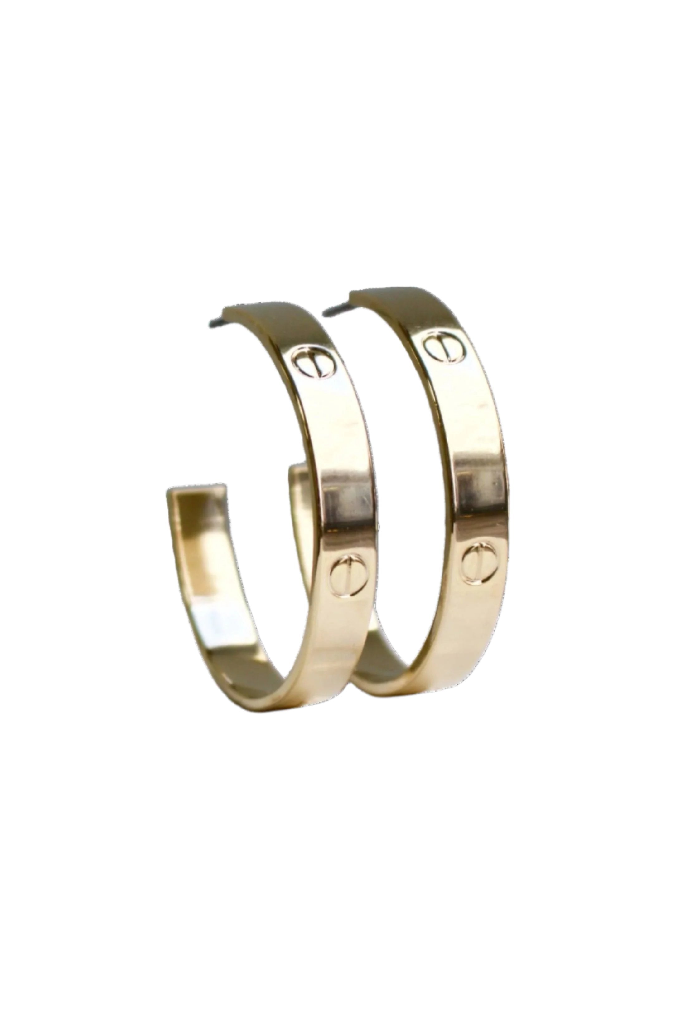 Close up view of nailhead gold hoops with engraved nailhead design