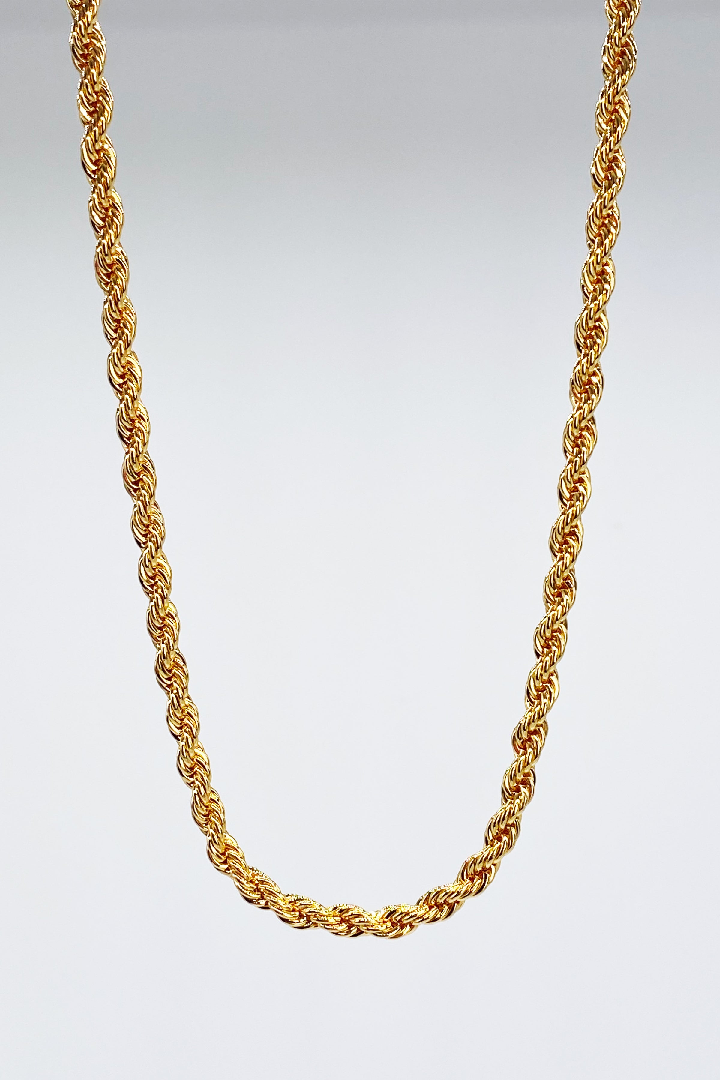 Textured Rope Chain Necklace in textured gold hanging on a gray background - L'Atelier Global