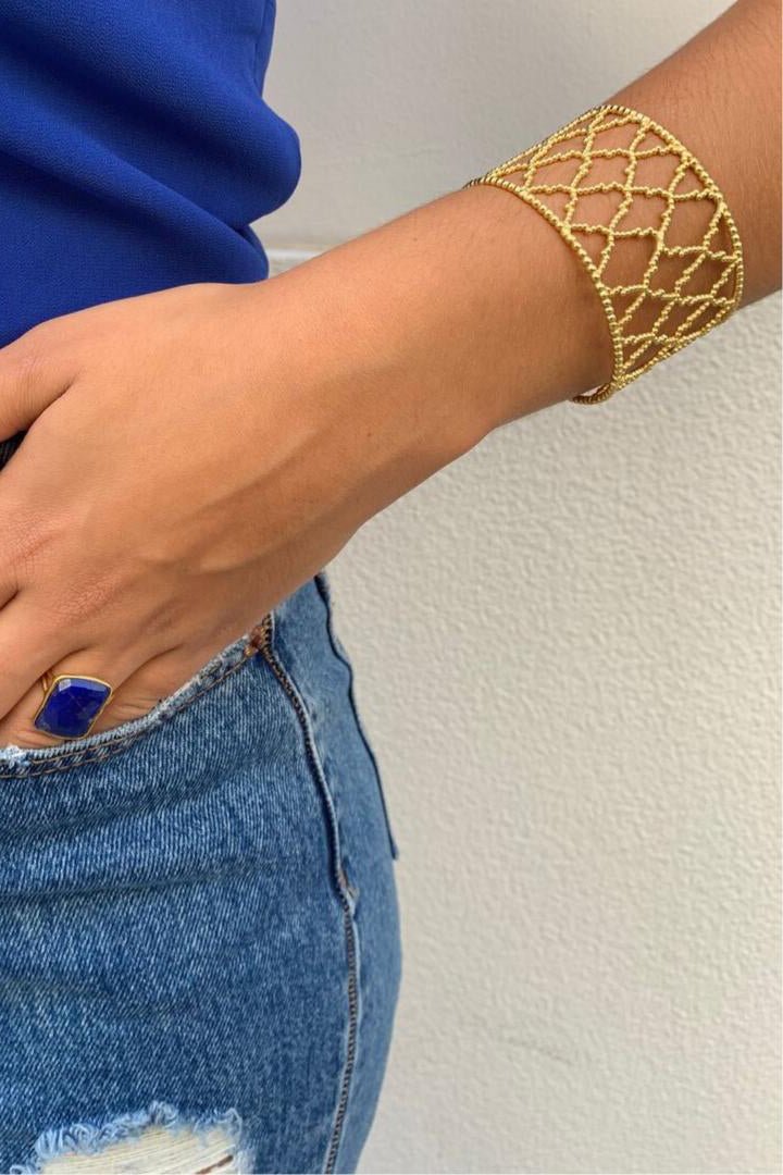 Alhambra Spanish Lattice Cuff Bracelet on a models left hand that is in her blue jeans pocket