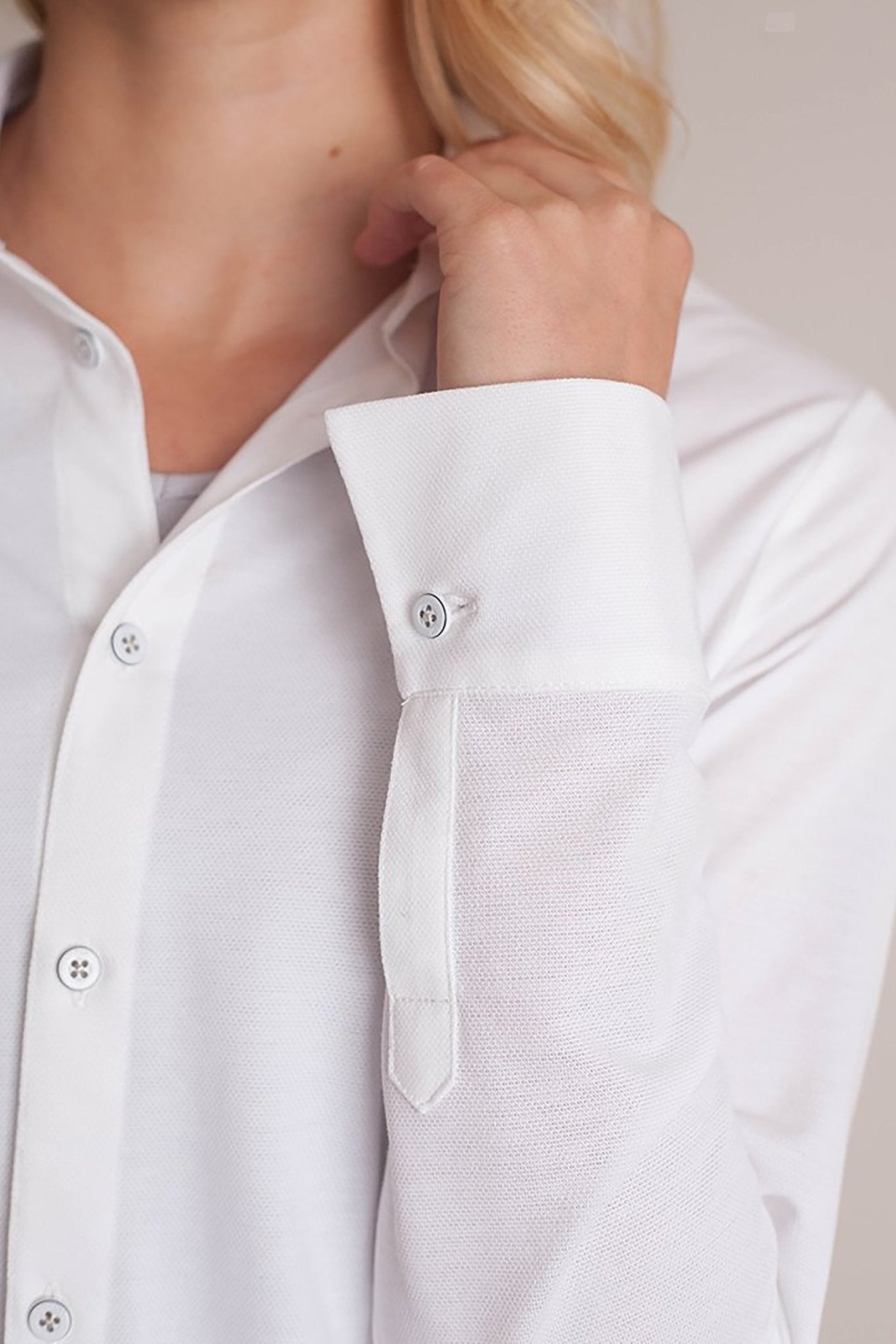 Cuff view of a female model wearing black pants and the All Day Comfort White Shirt - L'Atelier Global