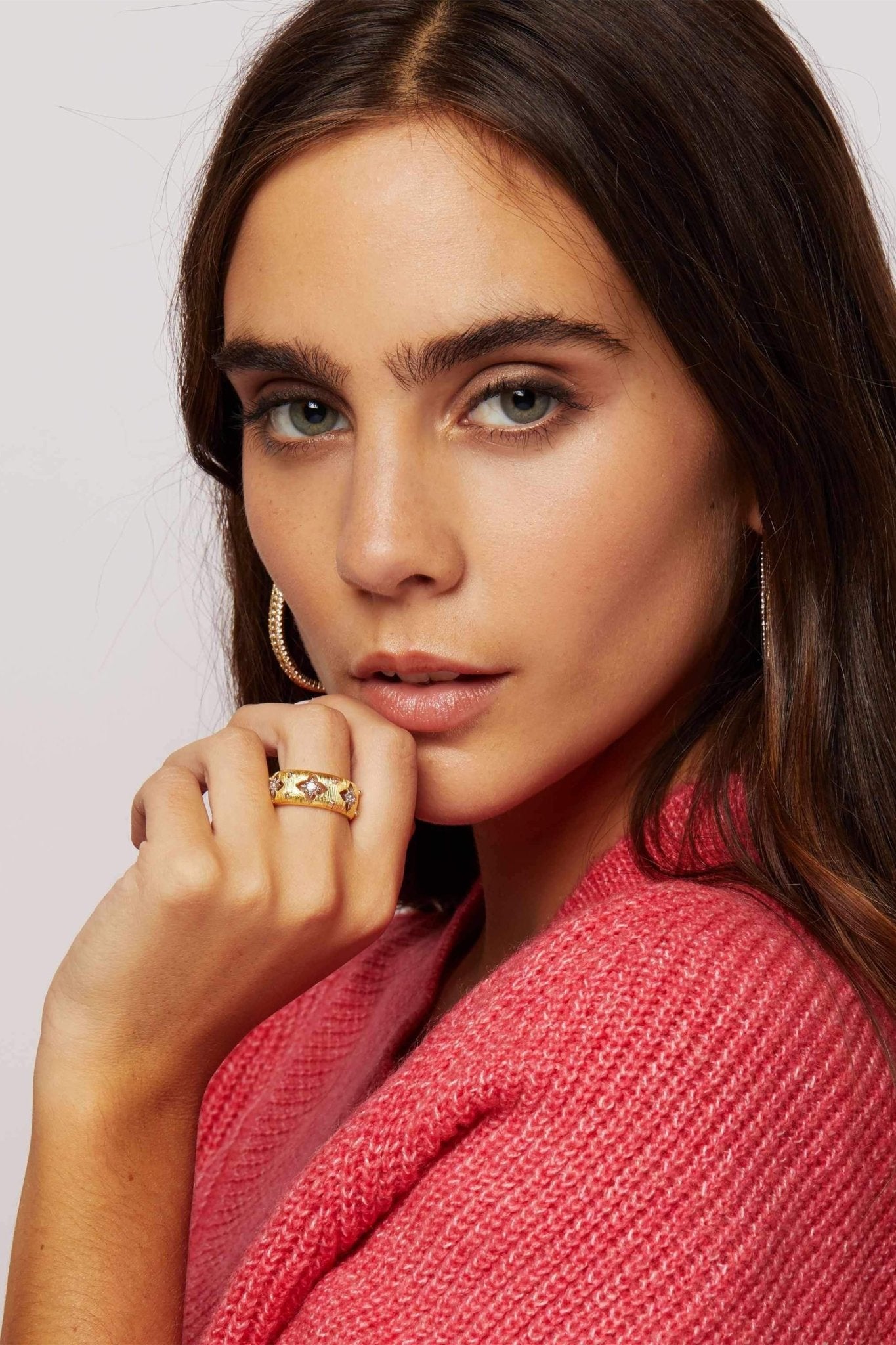 Antique Brushed Gold Sunburst Ring on a model wearing a tomato red sweater