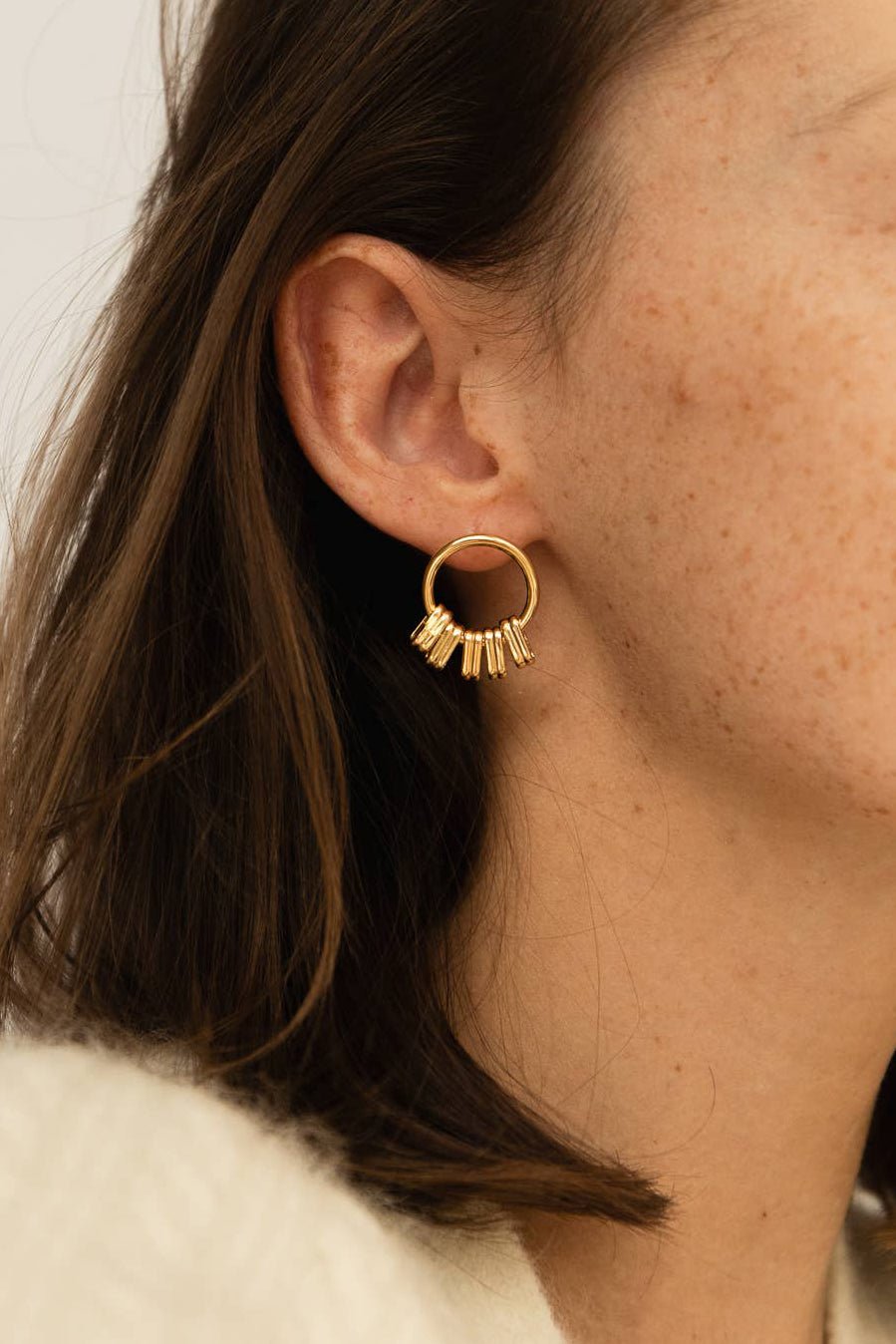 A woman wearing Ariège Gold Stud Earrings on her right ear.