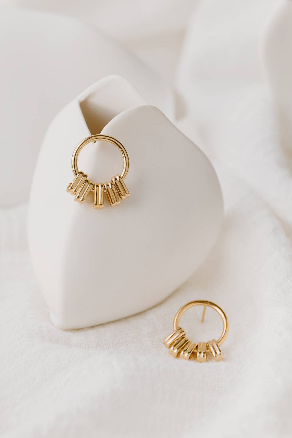 Ariège Gold Stud Earrings are styled on a white velvet backdrop.