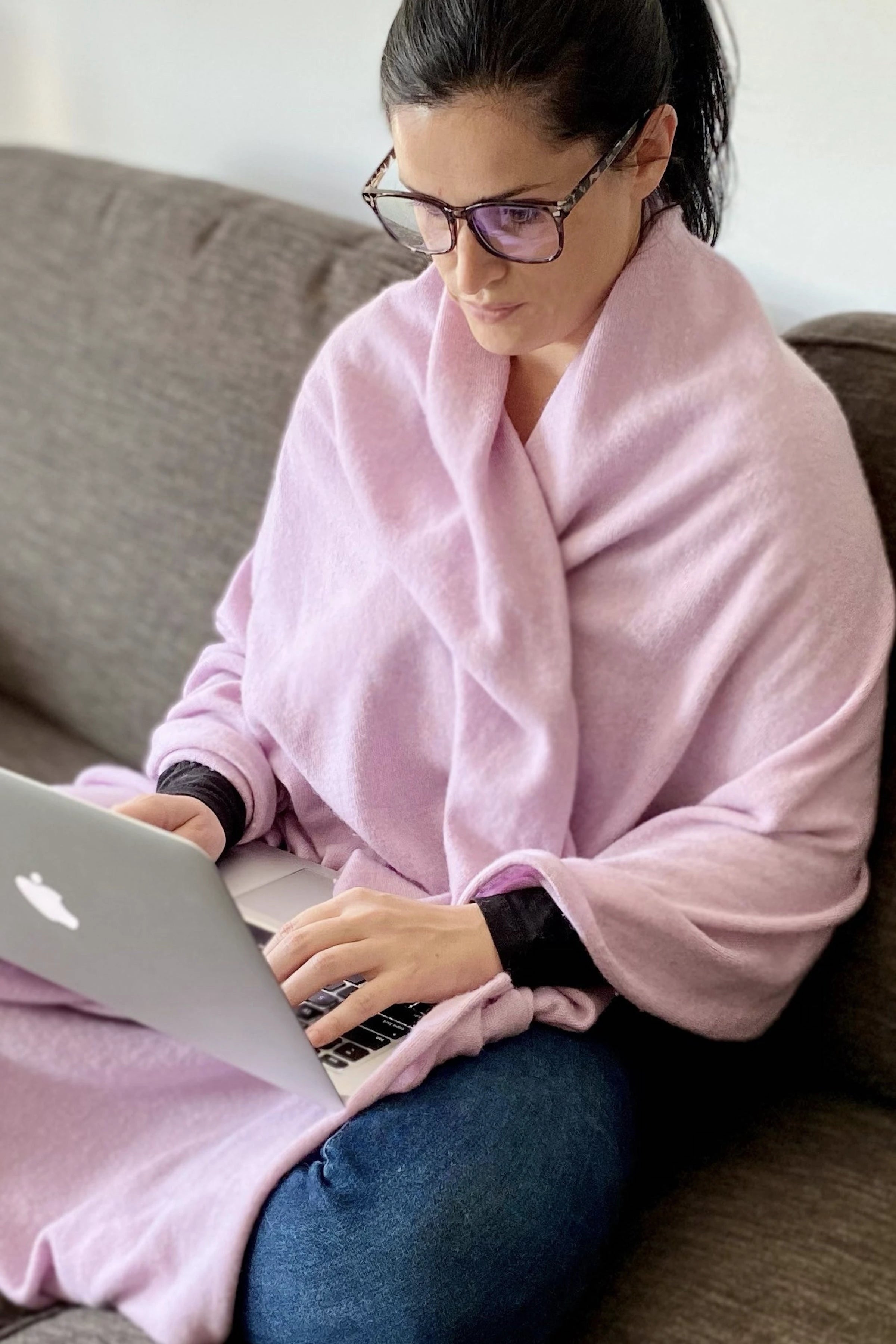 Avellina Italian Cashmere-Blend Wrap in pink on woman sitting on couch typing on her computer - L'Atelier Global