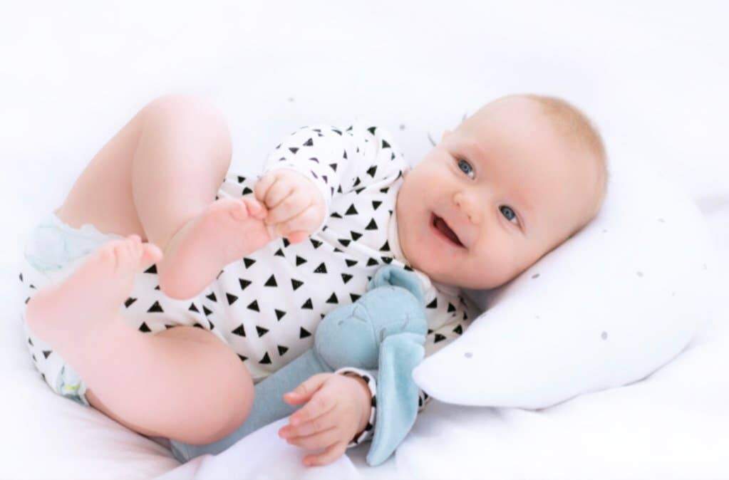 Baby Bunny Rattle in Blue in an adorable babies hands - L'Atelier Global