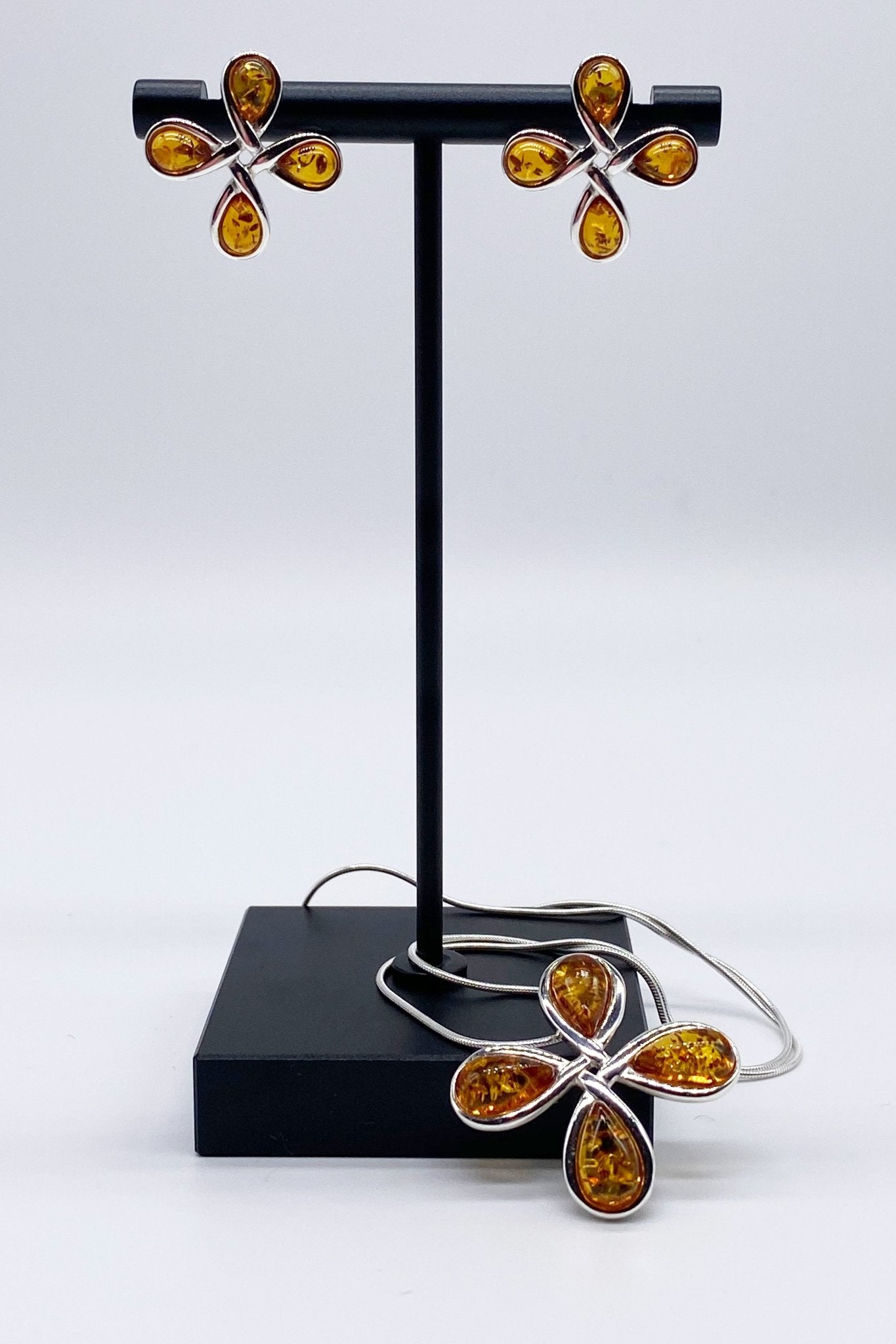 Baltic Honey Amber Petal Necklace and earrings presented on a jewelry stand - L'Atelier Global