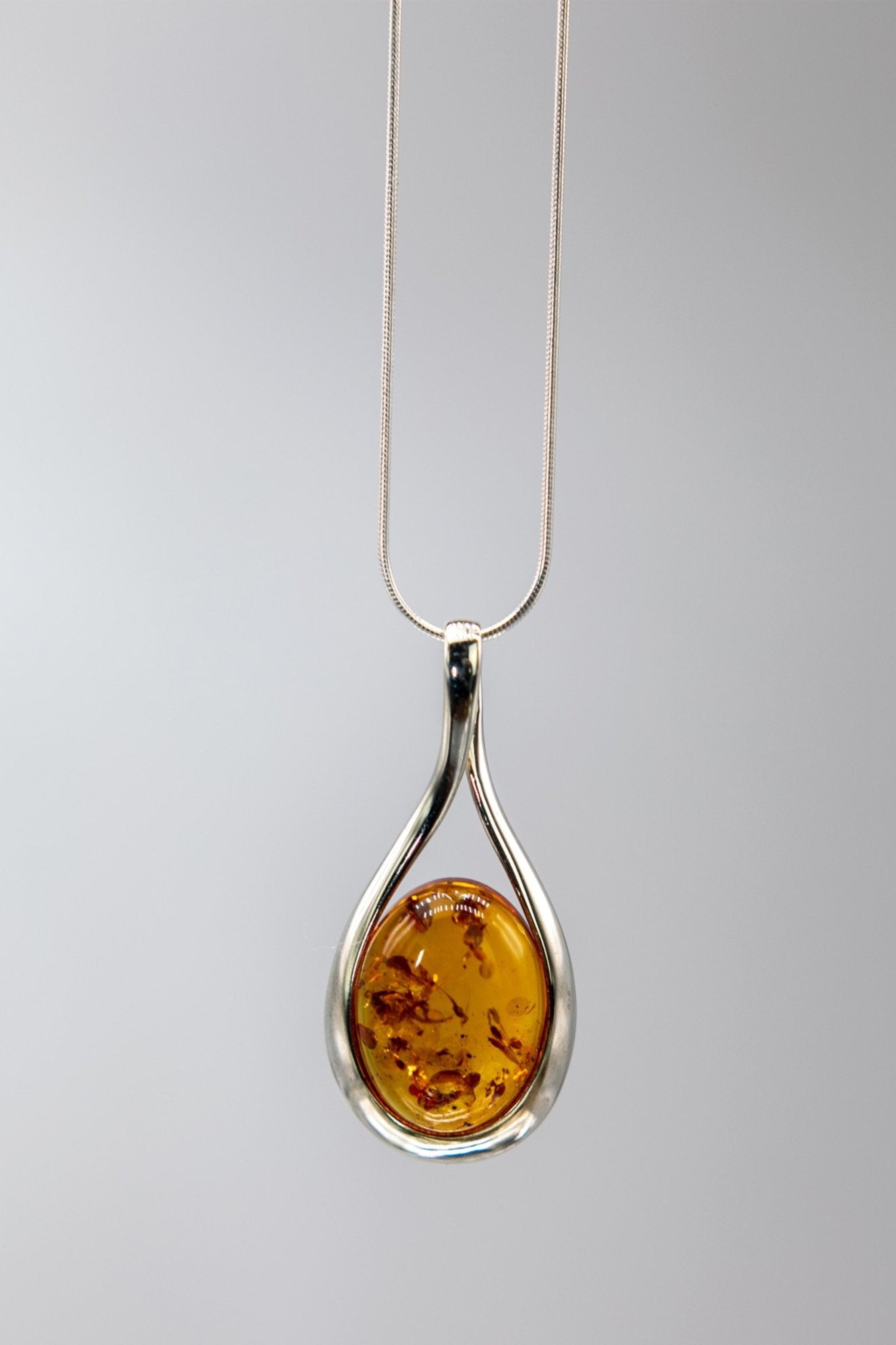 Baltic Honey Amber Sculptured Tear Drop Necklace on a light gray background - L'Atelier Global
