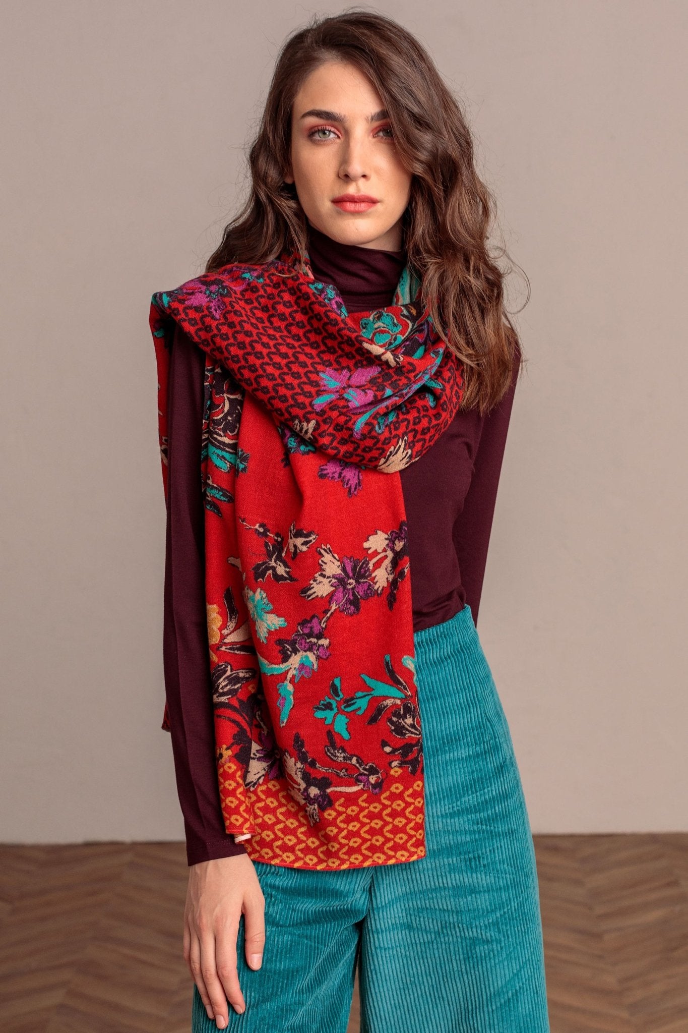 Botanical Garden Serbian Merino Wool Shawl in Red on a female model wearing a burgundy sweater and jeans