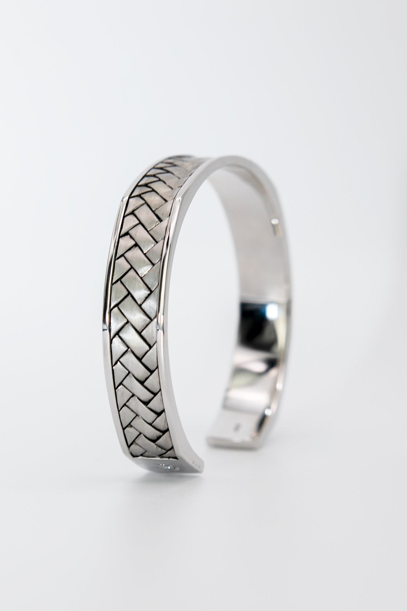 Broken Twill Weave Cuff Silver Bangle Side View on a grayish background