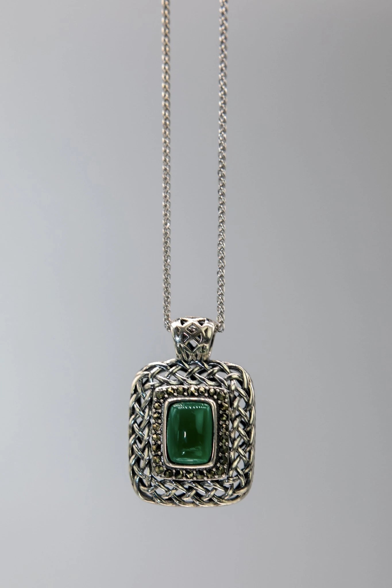 Irish Celtic Woven Agate Necklace hanging on a gray background - L'Atelier Global