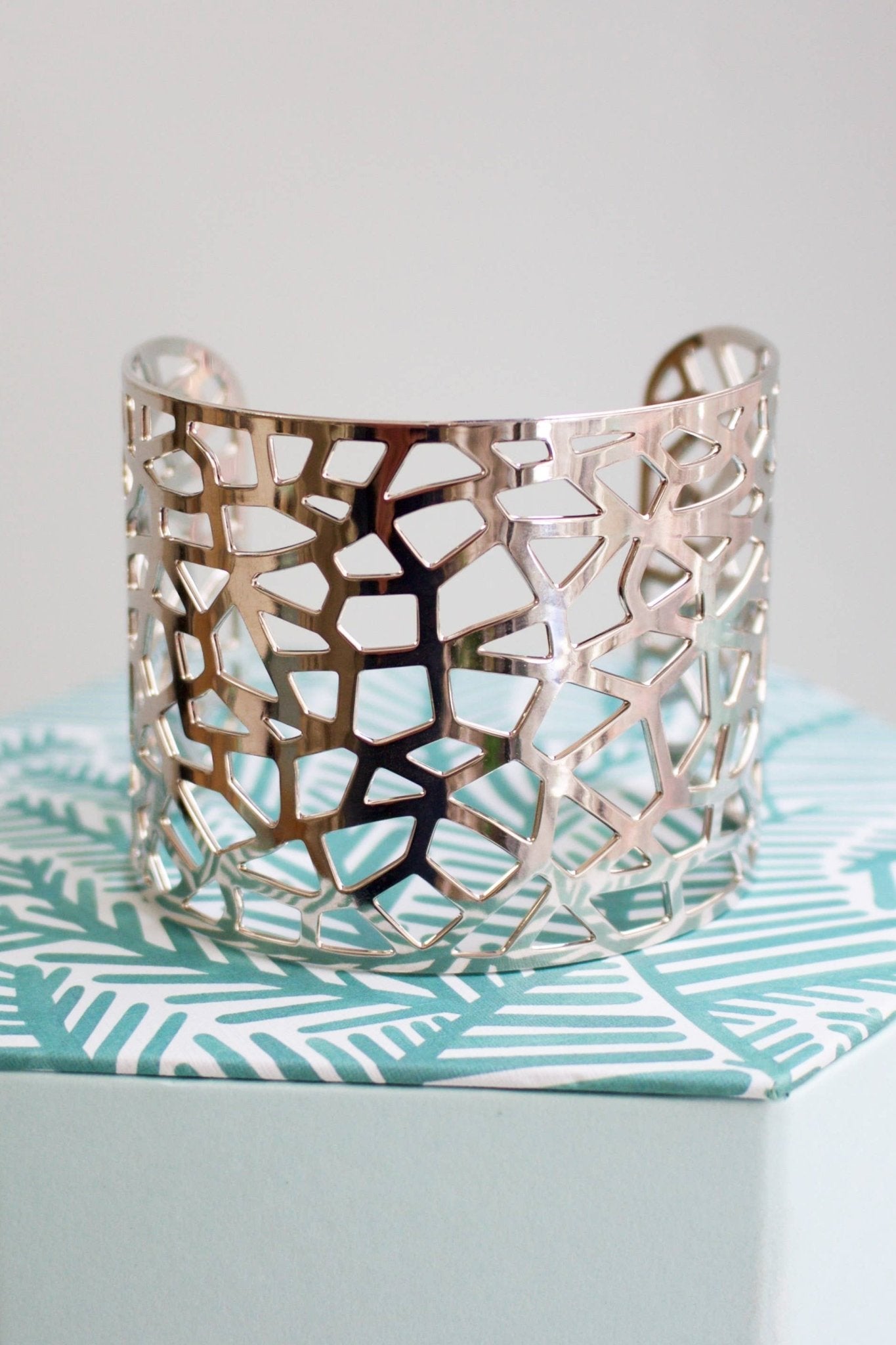 Chelsea Abstract Cuff in Silver sitting on a palm leaf fabric bench - L'Atelier Global