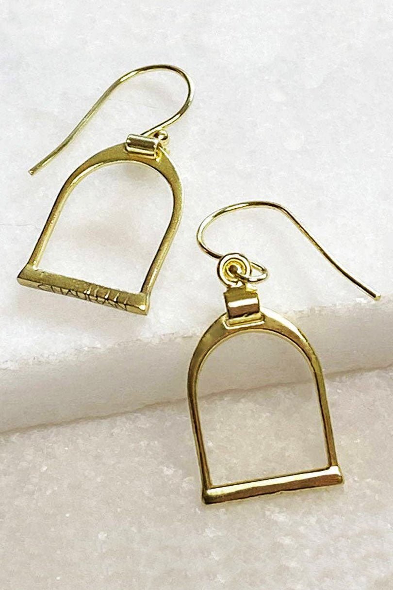 Classic English Stirrup Earrings in Gold on an ivory white quartz background