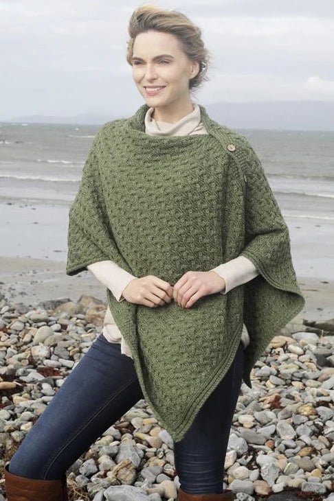 A female model wearing the Irish Clew Bay Supersoft Convertible Cape in green as a poncho