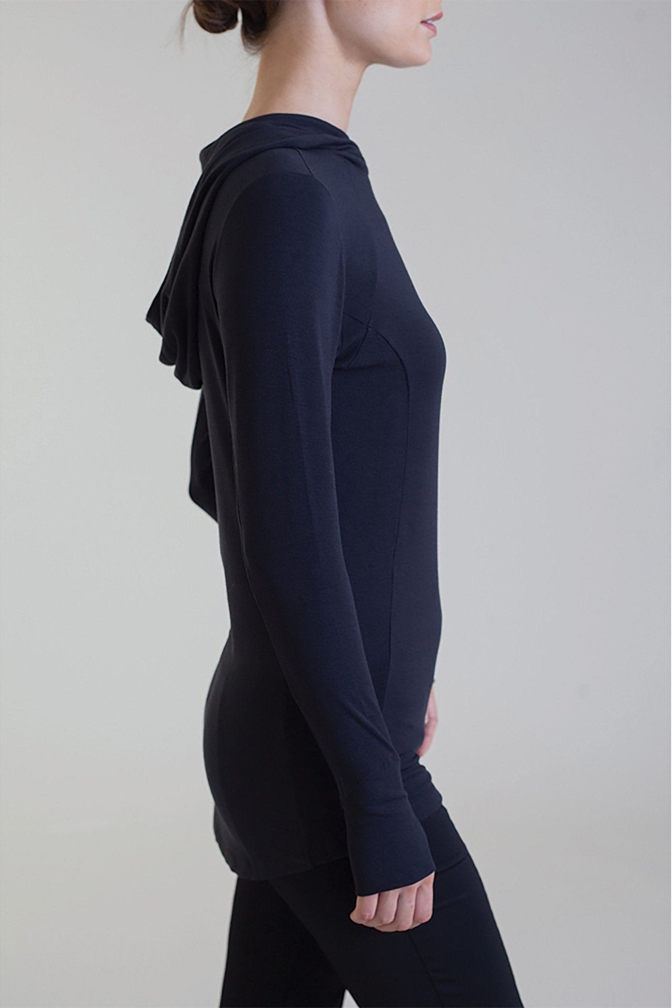 Side view of a female model wearing black pants and the Comfort Collagen Hoodie - L'Atelier Global