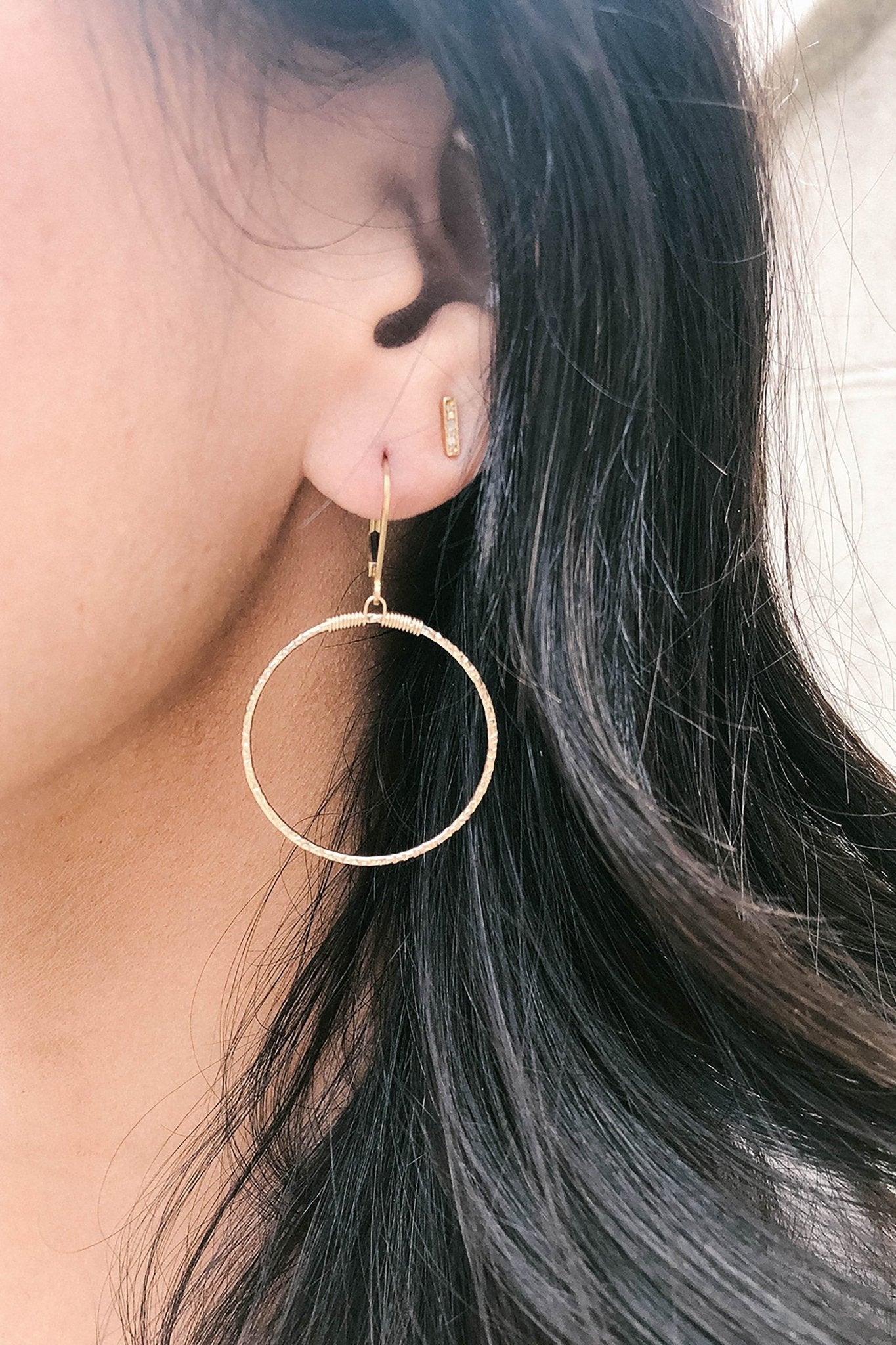Dazzling Hammered Hoops in gold on a female model