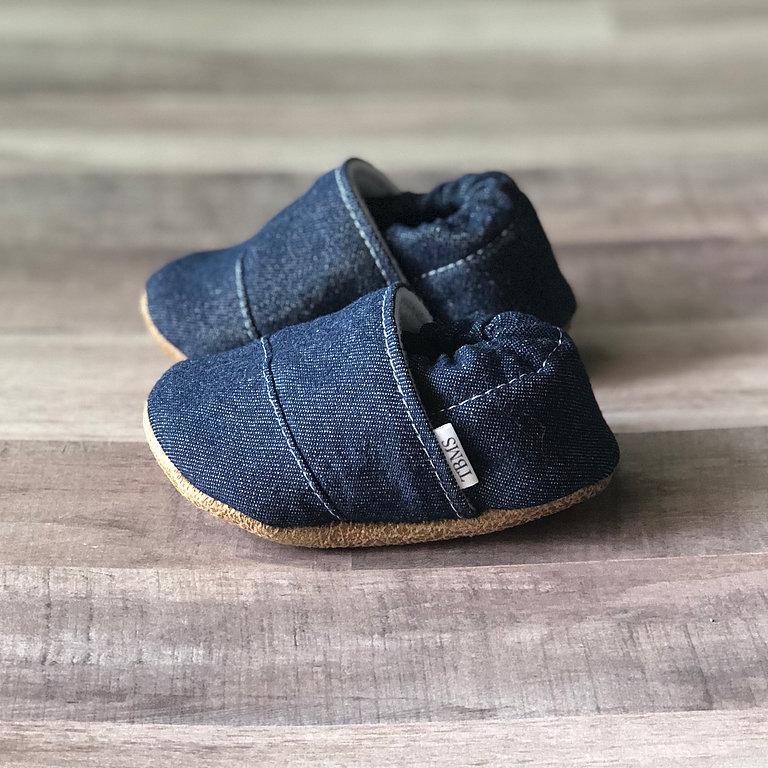 Baby Moccasins in Denim photographed on a wooden floor, showing profile