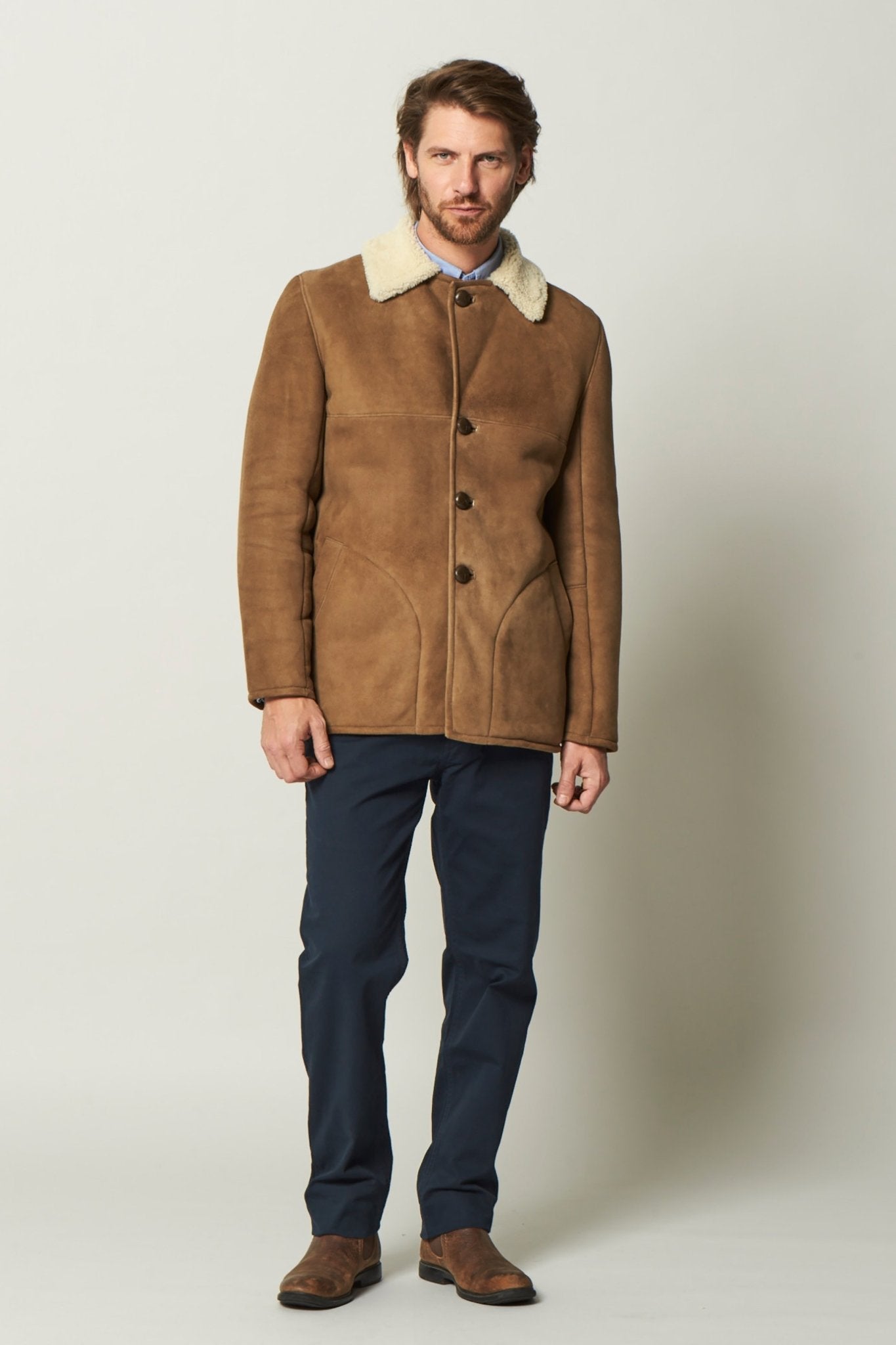 Dorset Sheepskin Jacket in Brandy buttoned up on a male model wearing black pants - L'Atelier Global