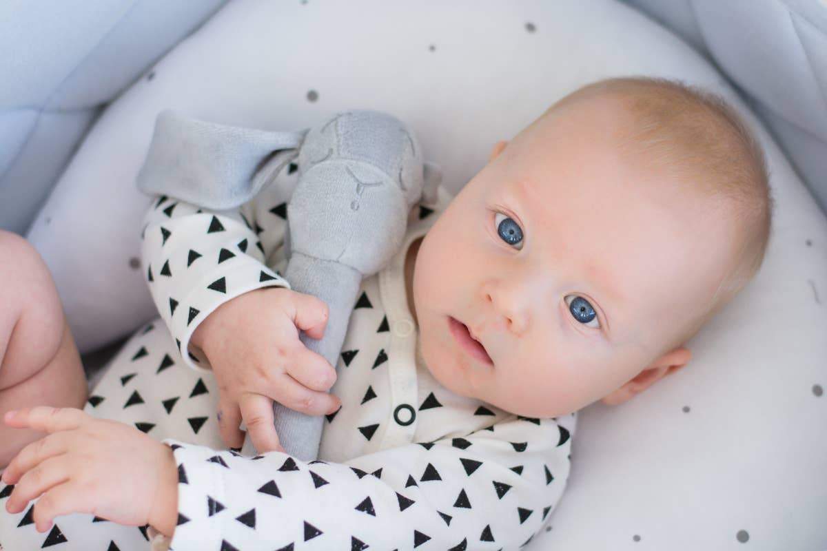 Effik Bunny Rattle in Gray on an adorable babies hands - L'Atelier Global
