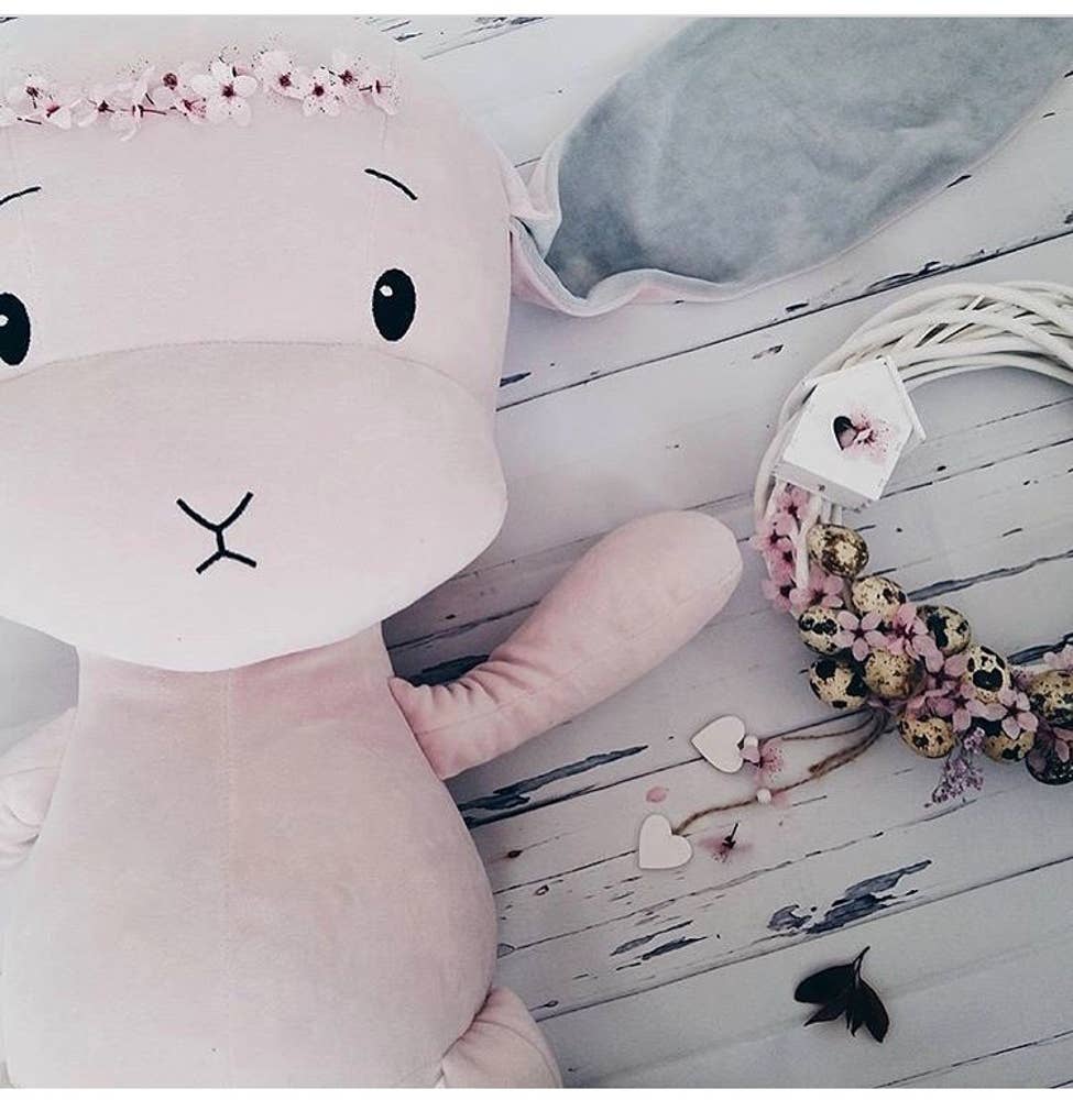 Effik The Pink Bunny laying on a wooden table next to dried pink flowers - L'Atelier Global