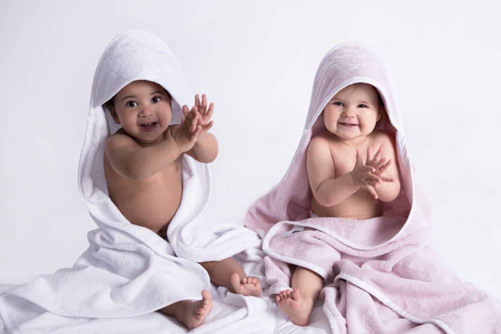 Embroidered Hooded Towel in White and Pink on two smiling and happy babies - L'Atelier Global