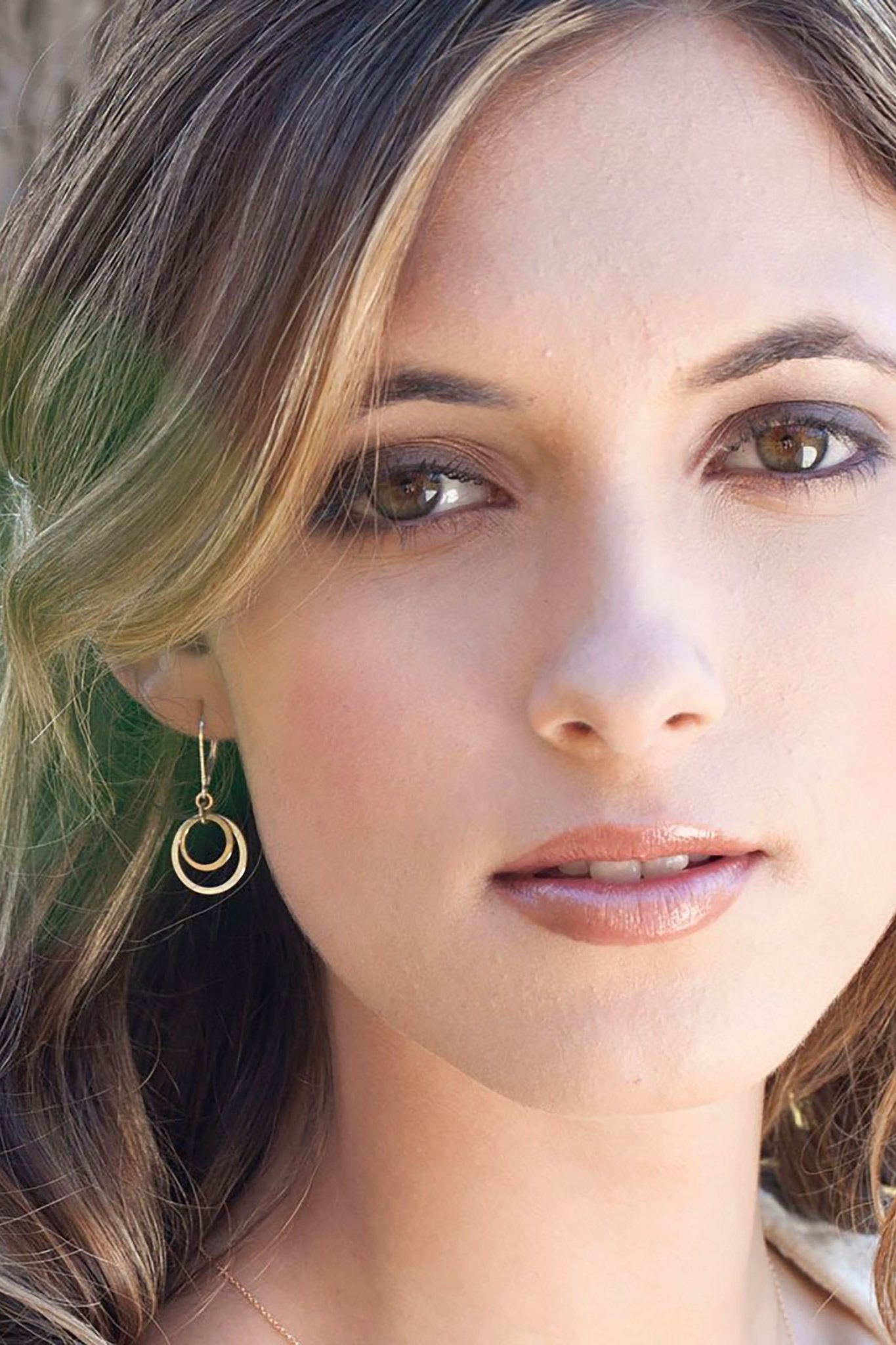 Endless Circles Silver Earrings on a female model showing the earrings on her right ear - L'Atelier Global