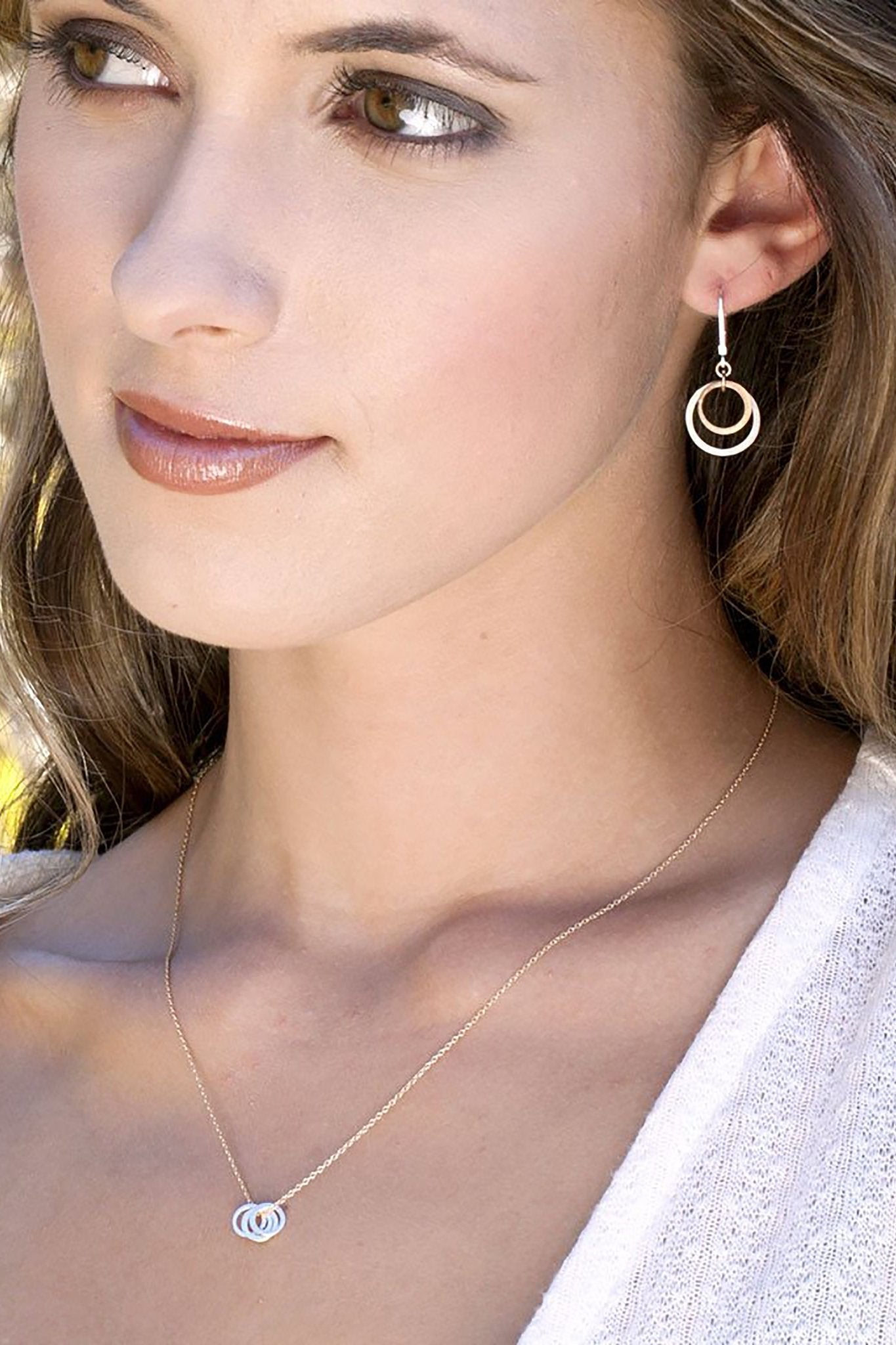 Endless Circles Silver Earrings on a female model showing the earrings on her leftear - L'Atelier Global