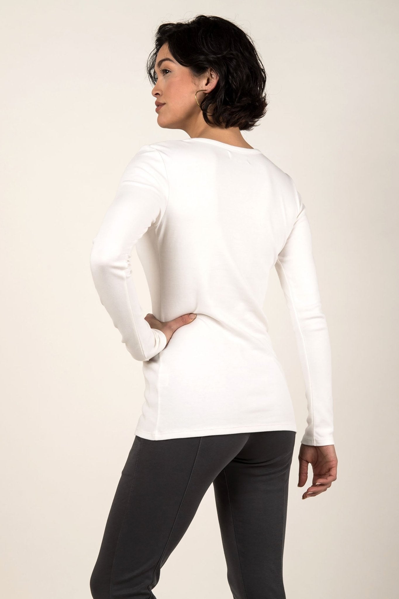 Essential Pima Cotton Layering Tee in white back view on female model wearing black pants. Length comfortably covers her hips