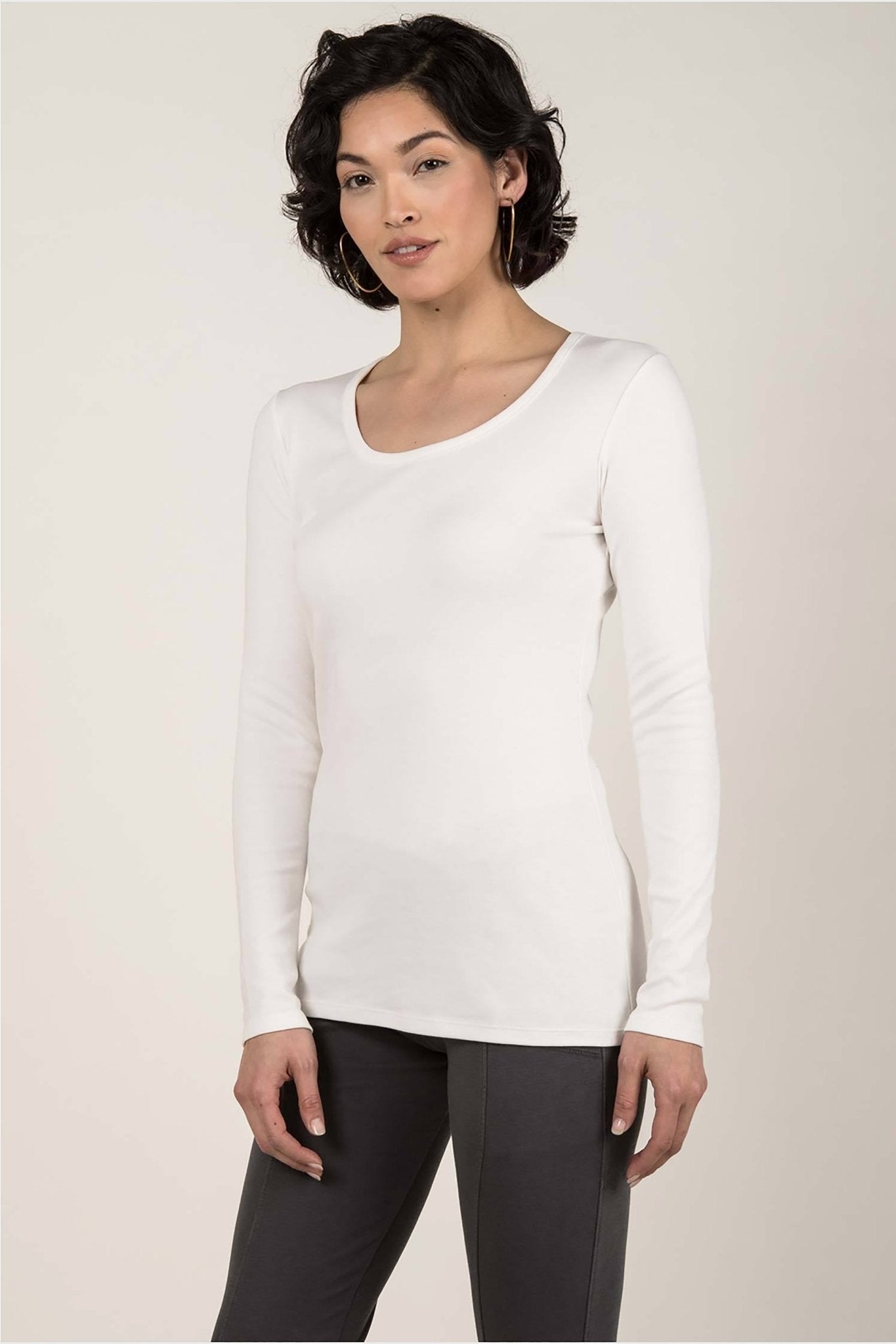 Essential Pima Cotton Layering Tee in white on female model wearing black pants. The shirt length comfortably covers her hips