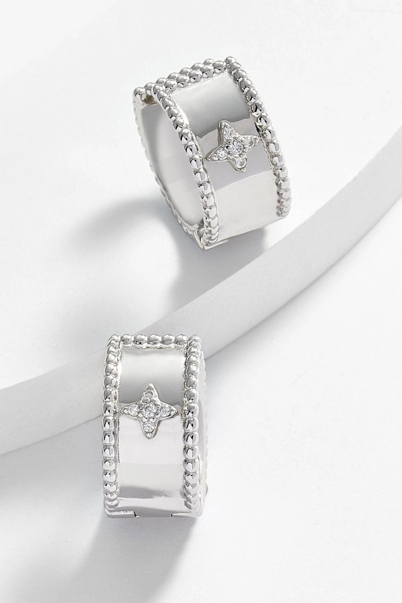 Firenze Cuff Star Earrings in silver on a white background. The vintage diamond star shape is seen in the front of the hoop.