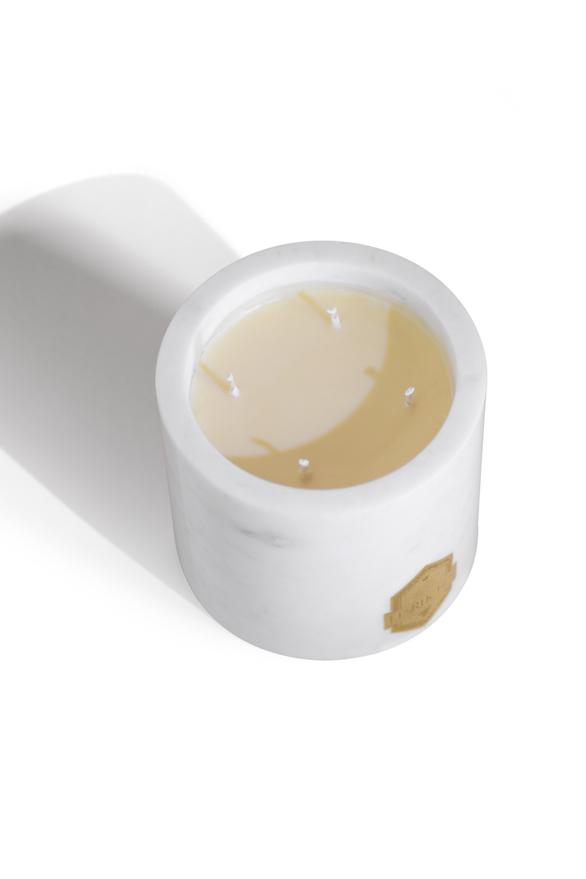 Gardenia Beauté Marbré Beeswax Candle 32 oz on a white table with its shadow behind it