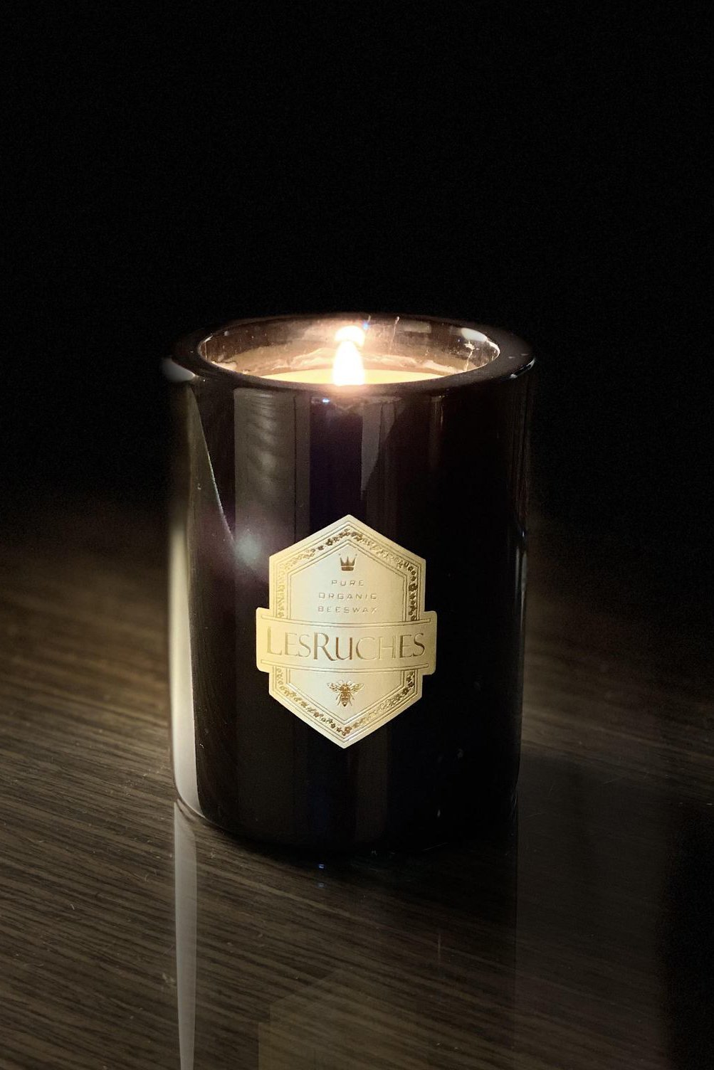 Gardenia Noir Marbre Partfaite Beeswax Candle 8 oz lit on a wooden table on a dark room