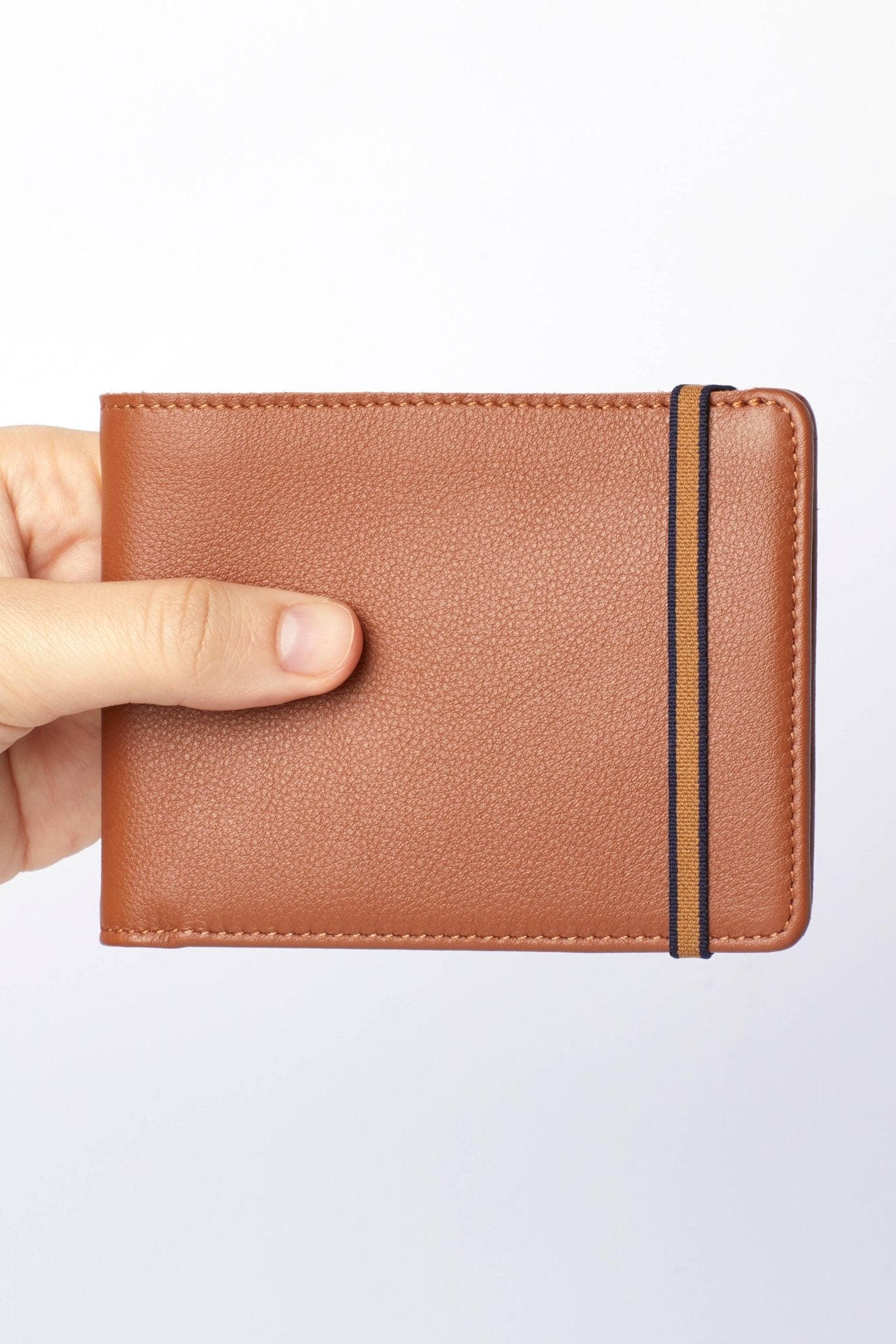 Gold Minimalist Wallet with black elastic closure on a white background - L'Atelier Global