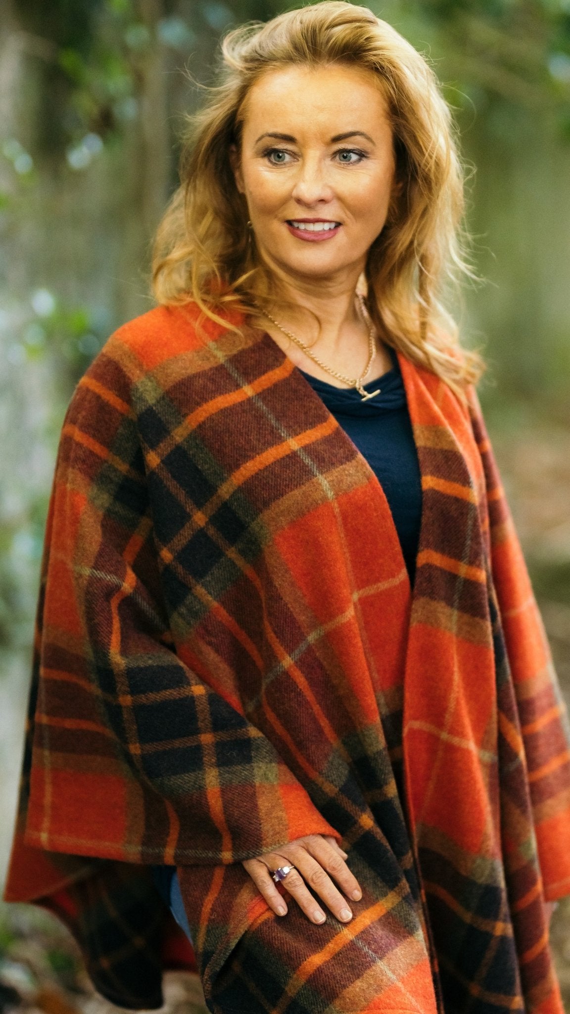 Harvest Tartan Ruana Wrap worn by a woman standing in front of trees