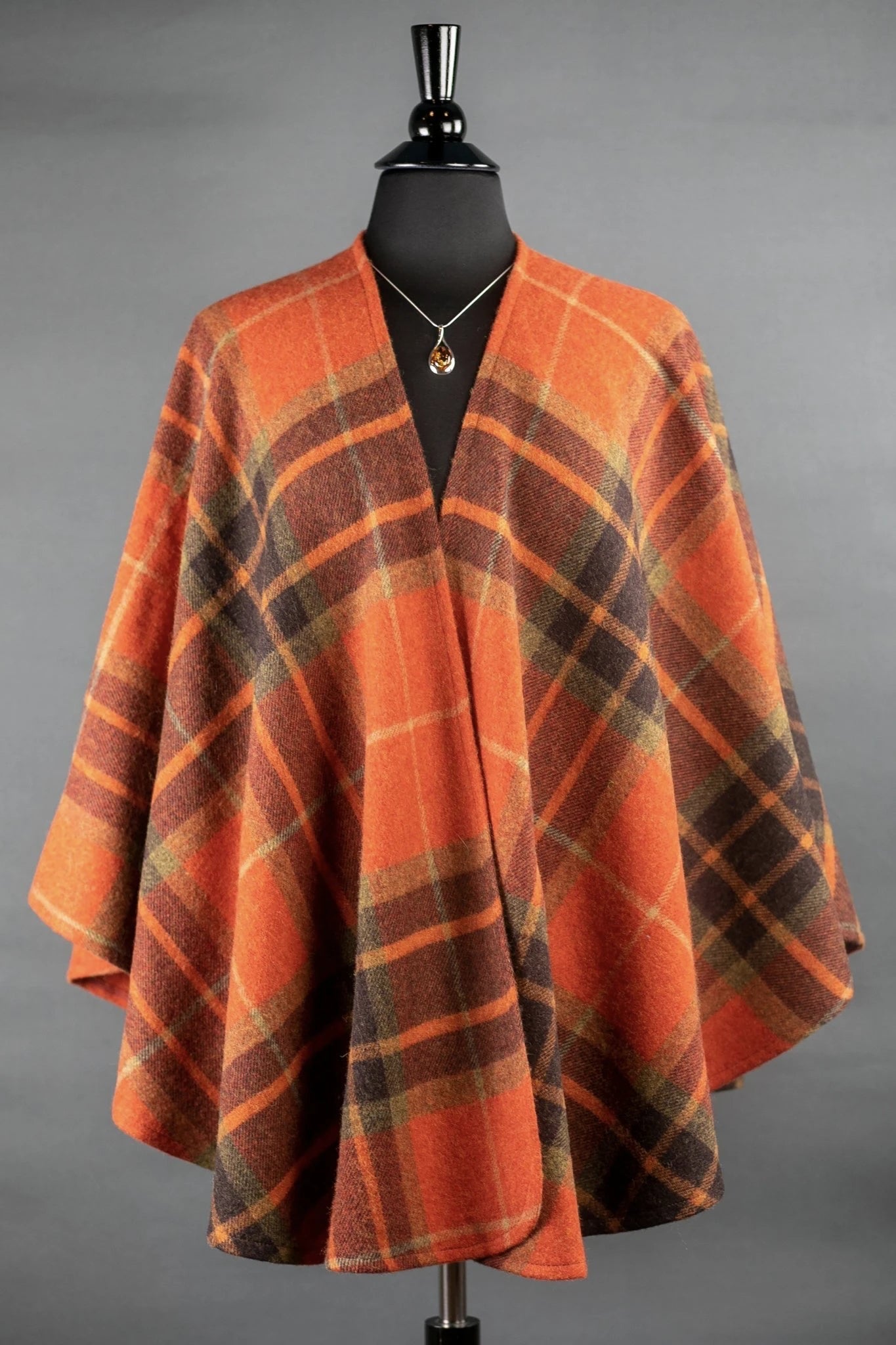 Harvest Tartan Ruana Wrap wrapped on a black bust form gray background