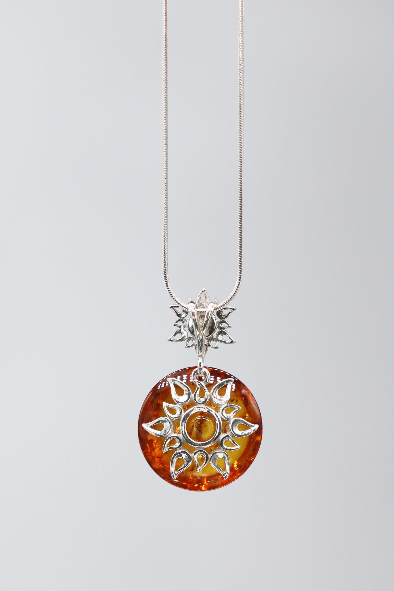 Honey Amber Star Necklace hanging on a gray background - L'Atelier Global
