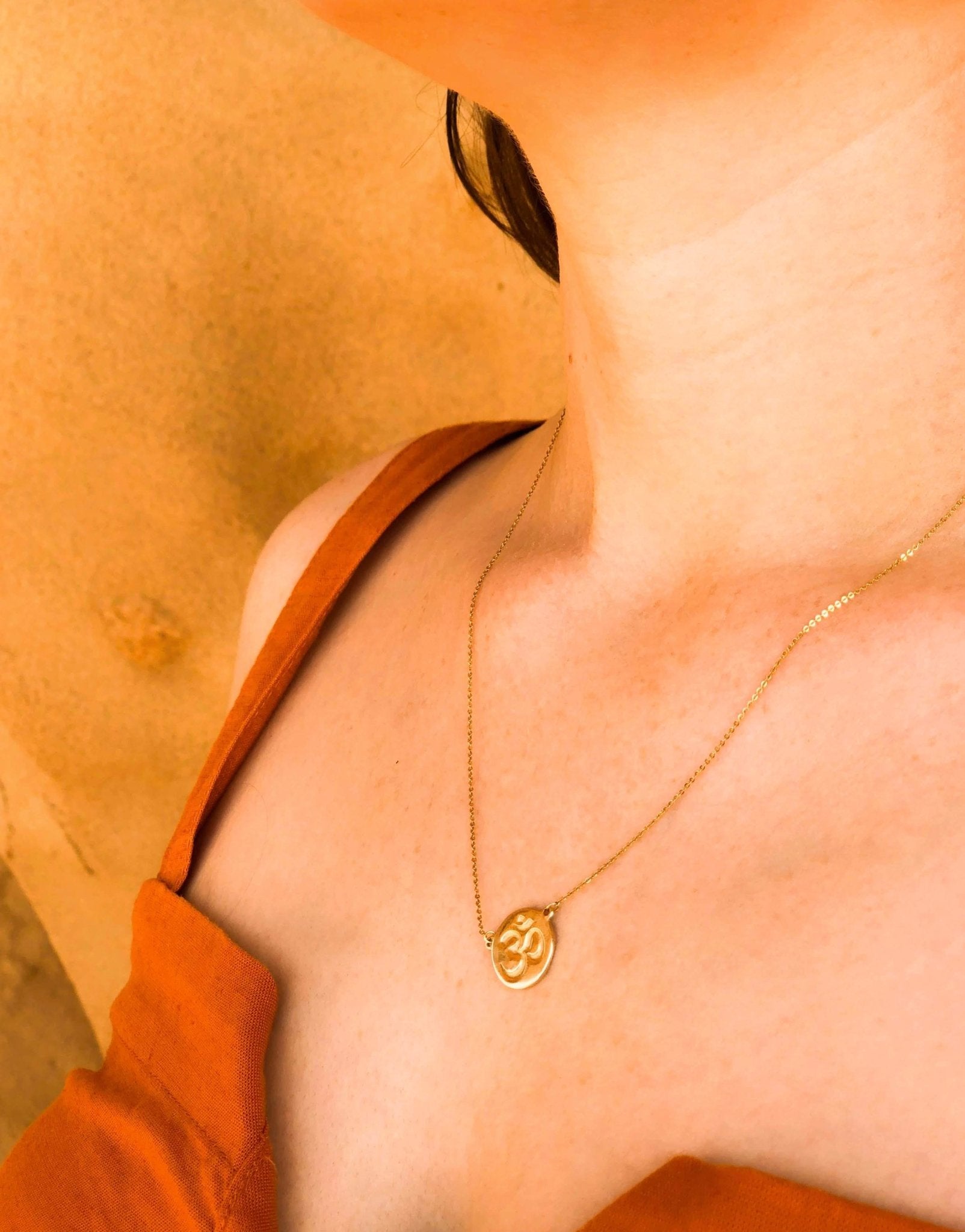 Inner Peace Gold Necklace on a model wearing an orange dress - L'Atelier Global