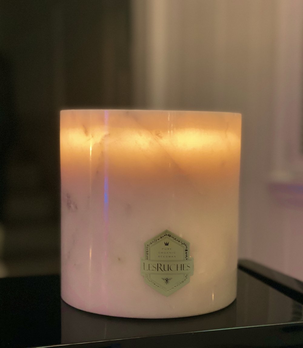 Jasmine Beauté Marbré Beeswax Candle 32 oz lit in a low lit room