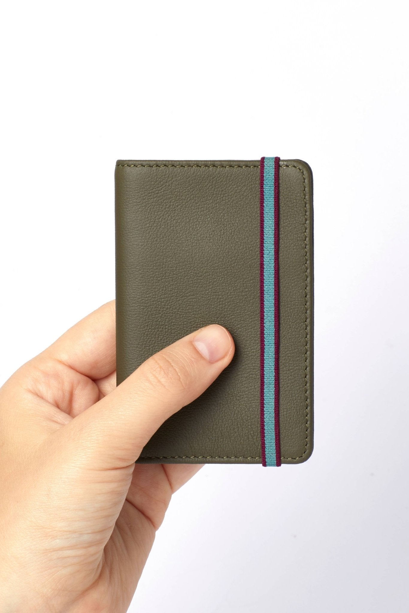 A man's hand is holding the Khaki Leather Card Holder on a white background - L'Atelier Global