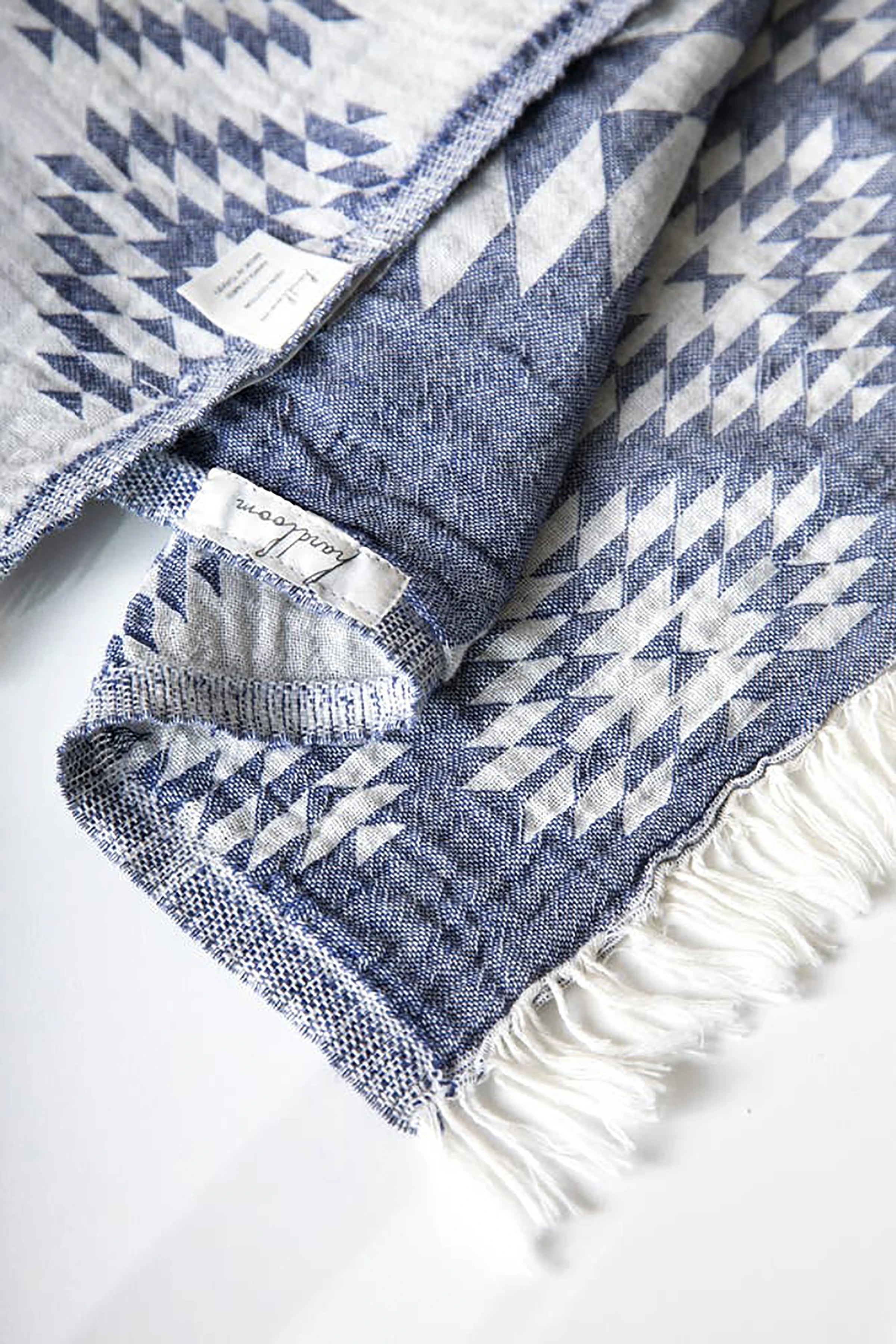 Kilim Motif Turkish Cotton Towel in dark blue and white with white fringe laying o a white background